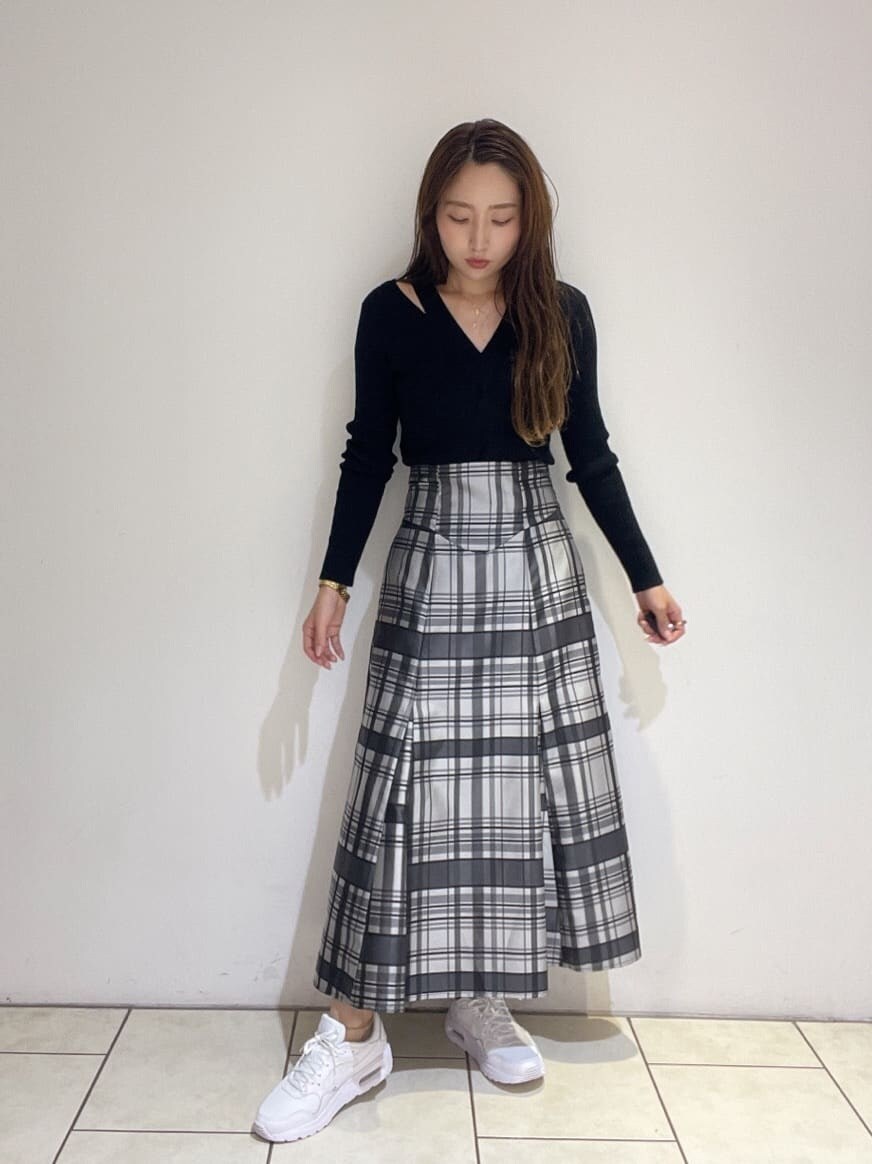 ブラック系のニット/セーター、ホワイト系のスニーカー、ブラック系のスカートを着用したレディースの秋コーディネートの3枚目の写真