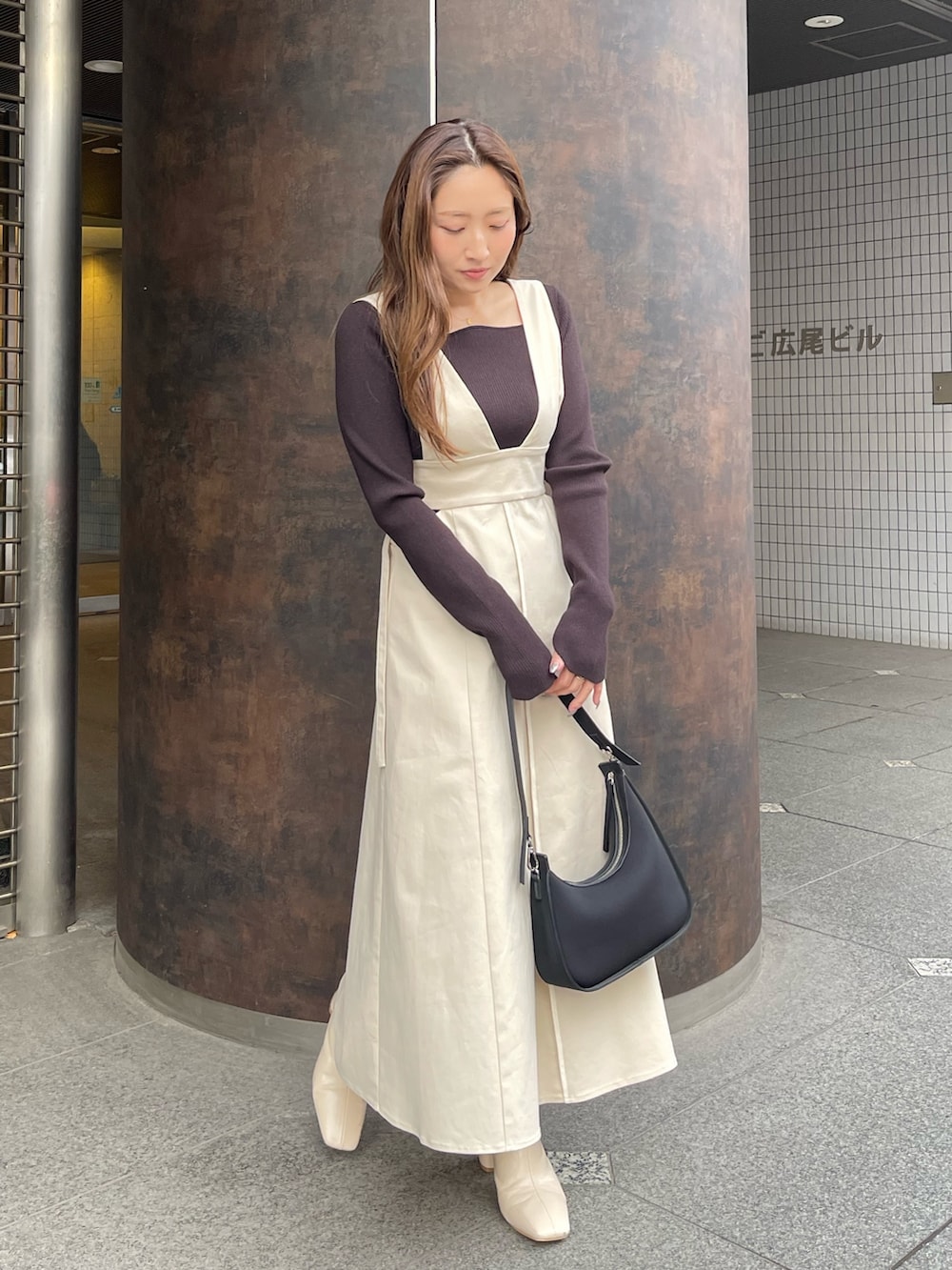 ホワイト系のブーツ、ホワイト系のジャンパースカート、ブラック系のニット/セーターを着用したレディースの冬コーディネートの5枚目の写真