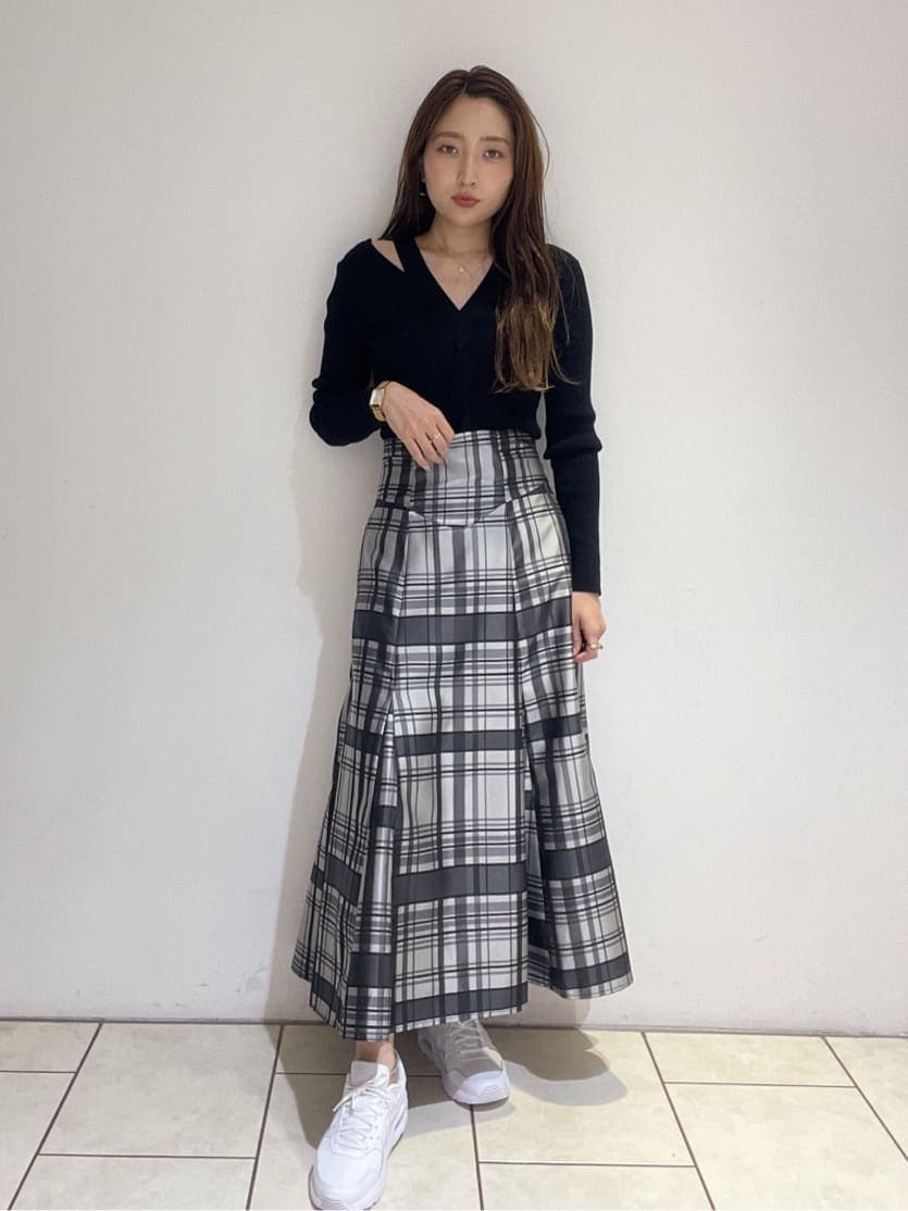 ブラック系のニット/セーター、ホワイト系のスニーカー、ブラック系のスカートを着用したレディースの秋コーディネートの5枚目の写真