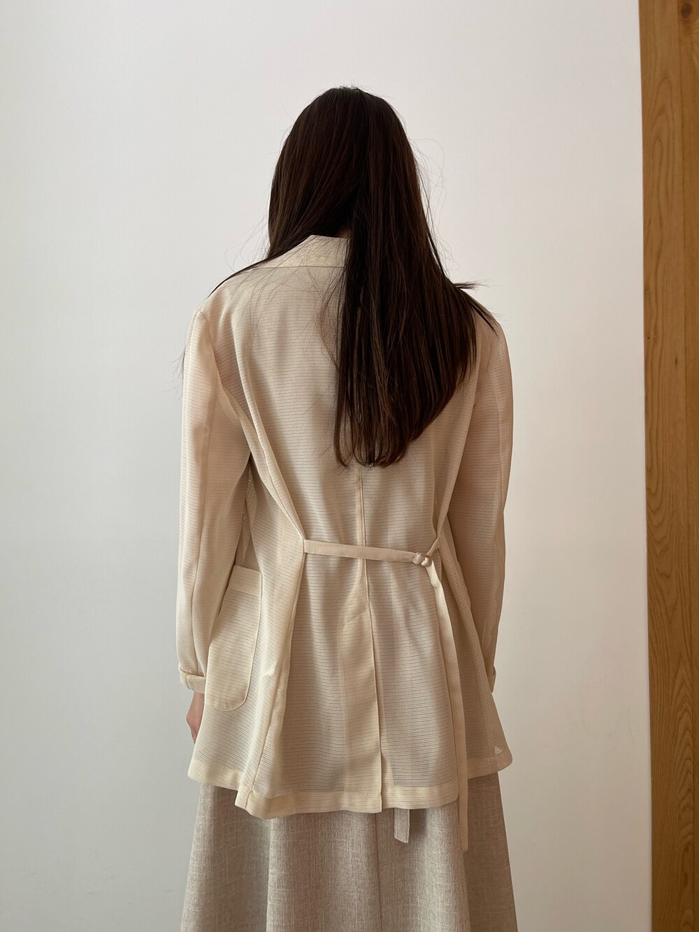 ベージュ系のワンピース、ホワイト系のサンダル、ホワイト系のテーラードジャケットを着用したレディースの夏コーディネートの5枚目の写真