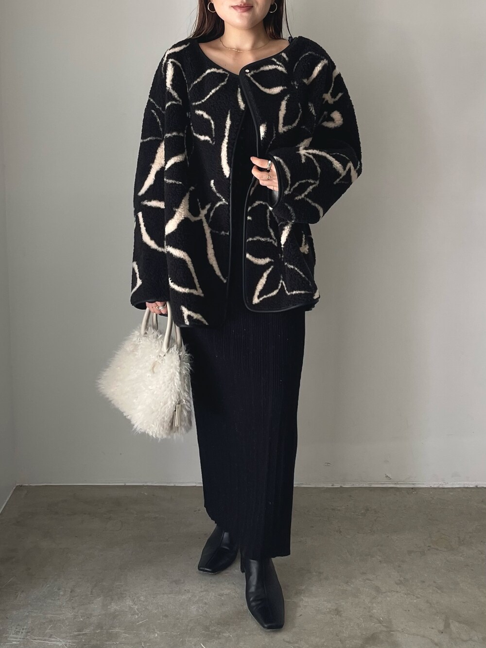 ブラック系のブーツ、ホワイト系のボストンバッグ、ブラック系のブルゾンを着用したレディースの秋コーディネートの6枚目の写真