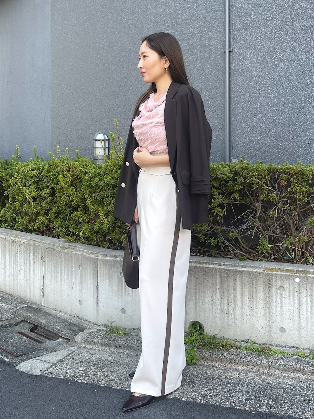 ブラウン系のハンドバッグ、ピンク系のシャツ/ブラウス、ブラック系のパンプスを着用したレディースの冬コーディネートの4枚目の写真