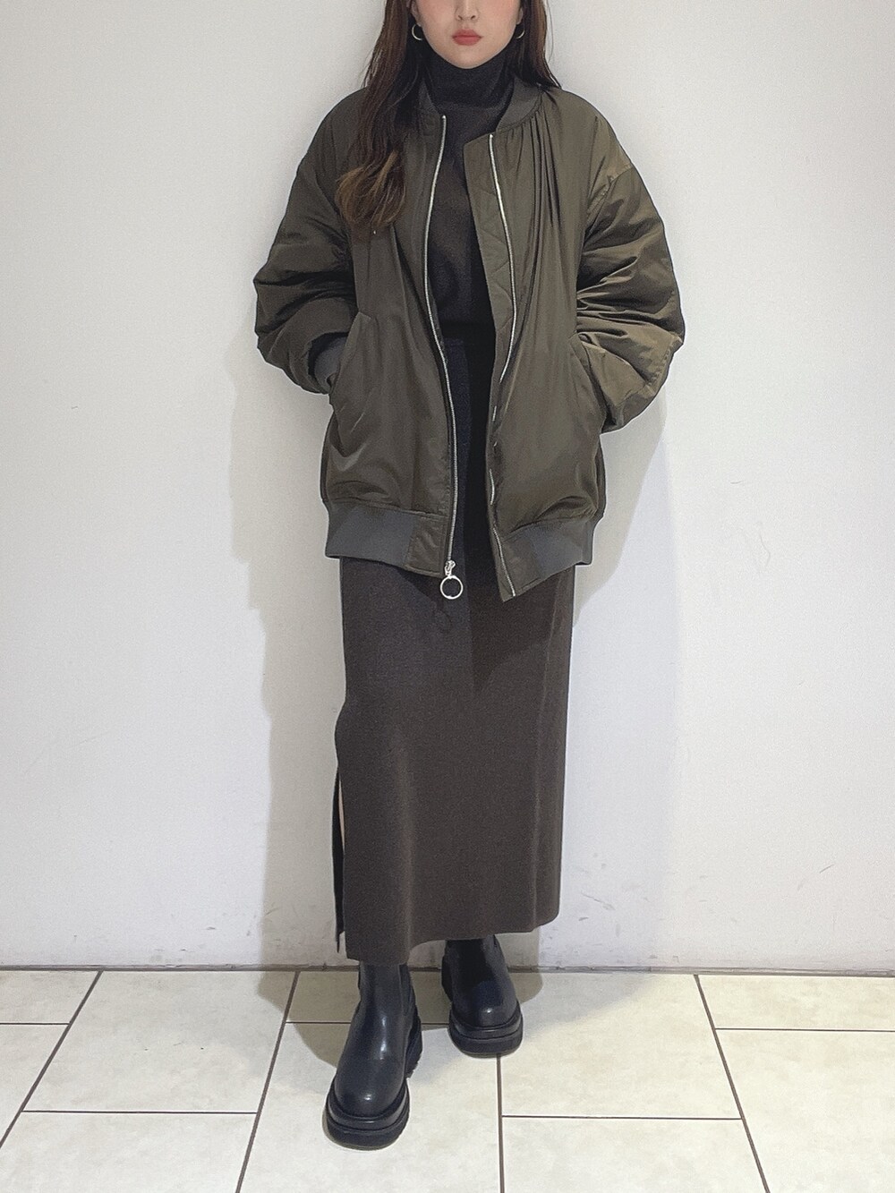 ブラウン系のニット/セーター、ブラウン系のスカート、ブラック系のブーツを着用したレディースの冬コーディネートの8枚目の写真