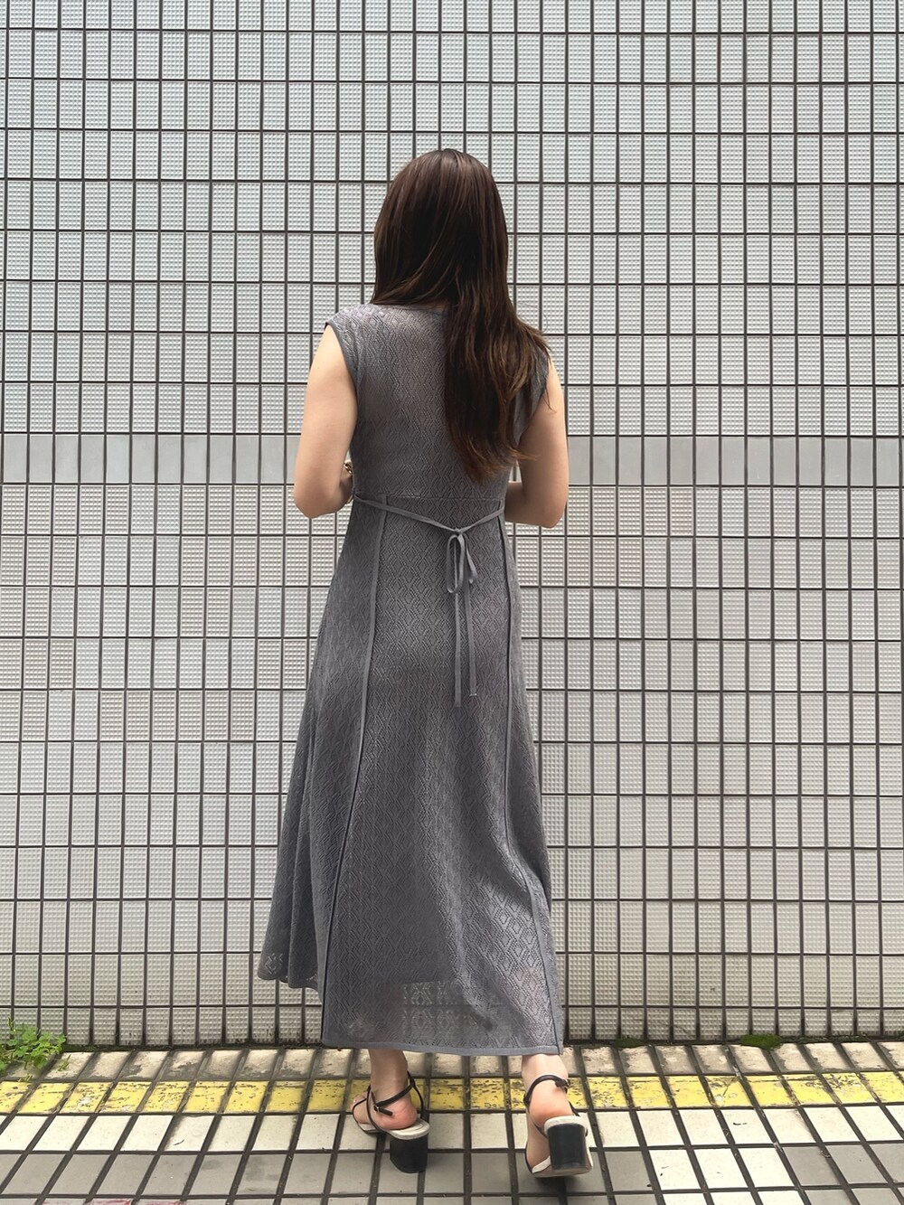 グレー系のワンピース、ブラック系のサンダル、グレー系のカーディガン/ボレロを着用したレディースの春コーディネートの10枚目の写真