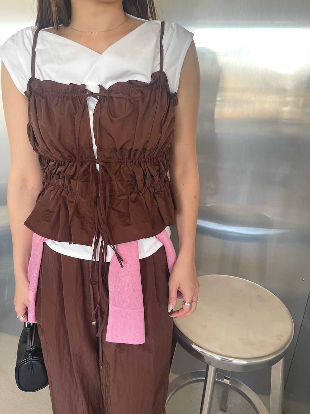 ブラック系のパンプス、ホワイト系のTシャツ/カットソー、ブラウン系のキャミソールを着用したレディースの春コーディネートの6枚目の写真