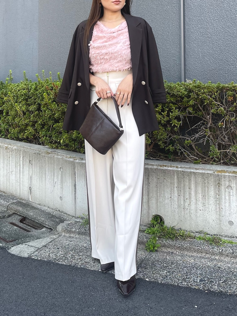 ブラウン系のハンドバッグ、ピンク系のシャツ/ブラウス、ブラック系のパンプスを着用したレディースの冬コーディネートの7枚目の写真
