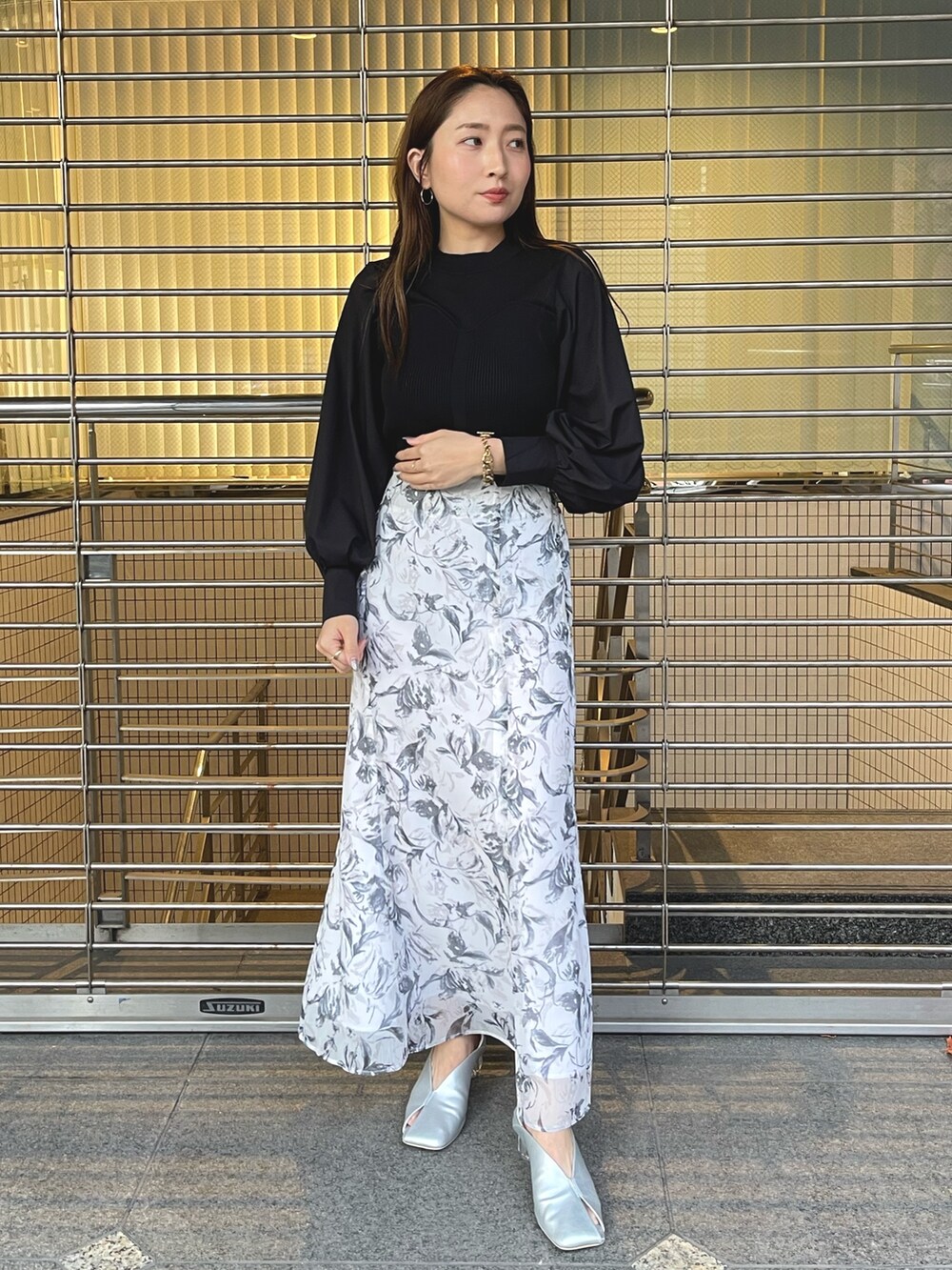 グレー系のスカート、シルバー系のパンプス、ブラック系のニット/セーターを着用したレディースの冬コーディネートの4枚目の写真