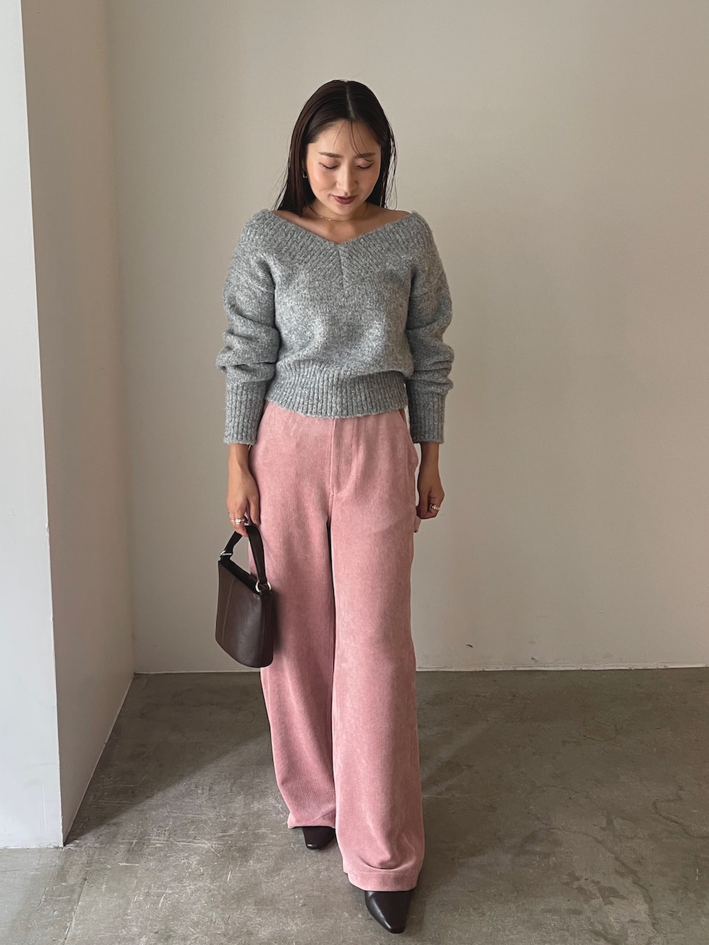 ブラウン系のハンドバッグ、ブラウン系のブーツ、ピンク系のその他パンツを着用したレディースの秋コーディネートの5枚目の写真