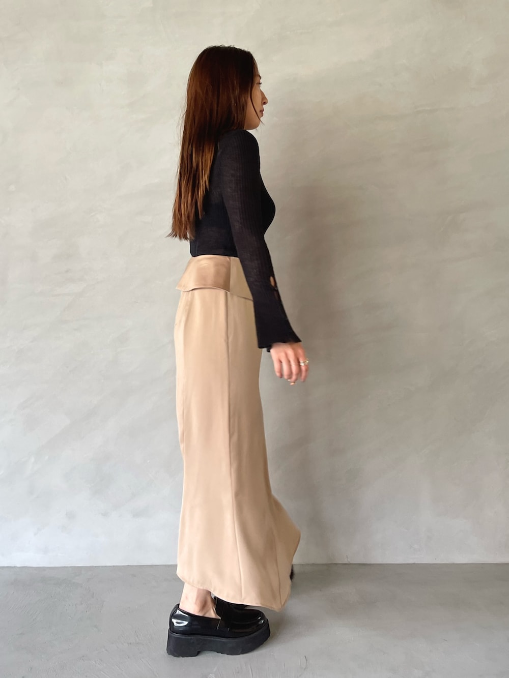 ベージュ系のスカート、ブラック系のニット/セーターを着用したレディースの夏コーディネートの4枚目の写真