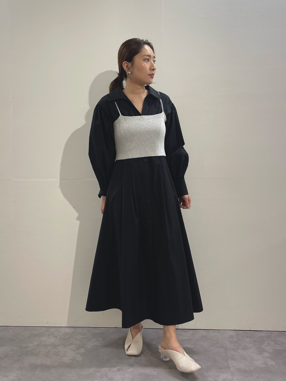 ホワイト系のパンプス、ブラック系のシャツワンピース、シルバー系のイヤリングを着用したレディースの冬コーディネートの6枚目の写真