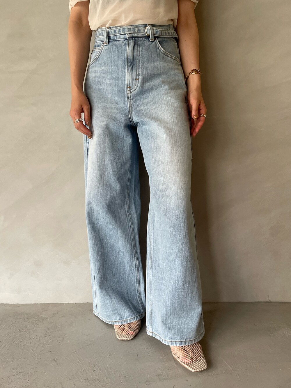 ブルー系のデニムパンツ、ホワイト系のTシャツ/カットソー、ホワイト系のサンダルを着用したレディースの夏コーディネートの10枚目の写真