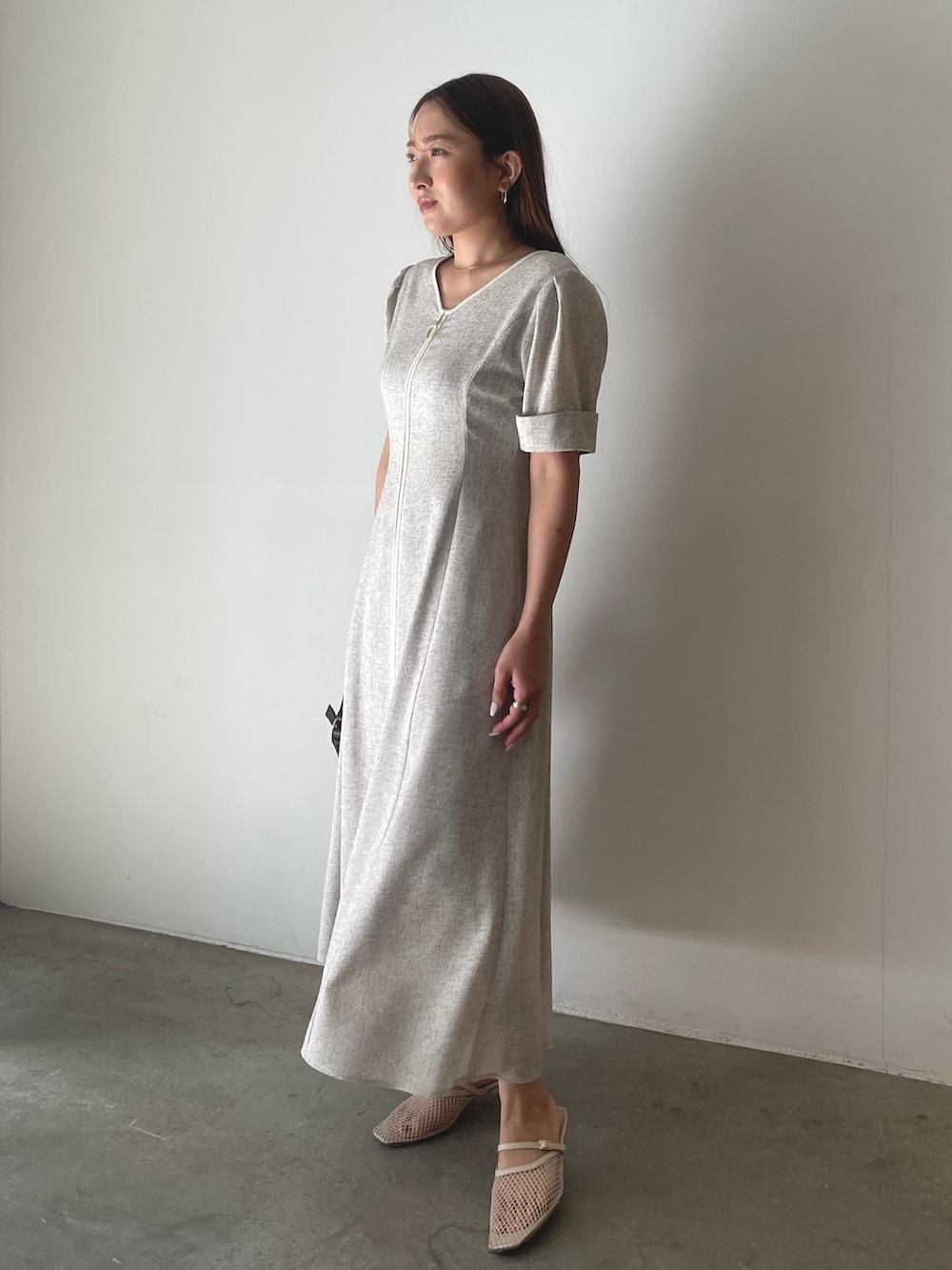 ブラウン系のハンドバッグ、ホワイト系のワンピースを着用したレディースの冬コーディネートの4枚目の写真