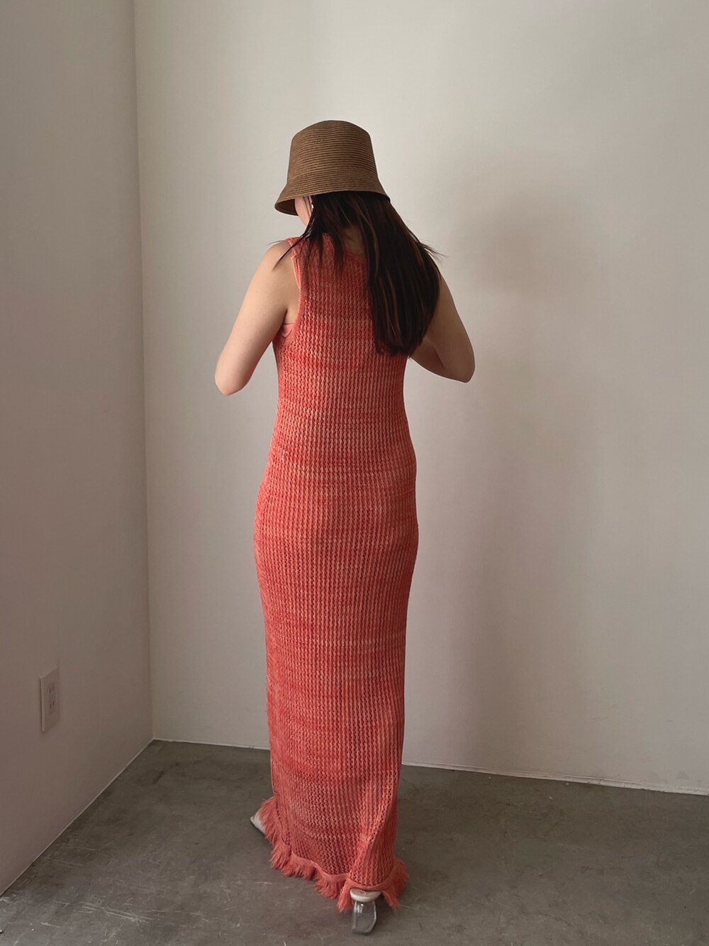 ホワイト系のサンダル、オレンジ系のワンピース、ブラウン系のハットを着用したレディースの春コーディネートの8枚目の写真