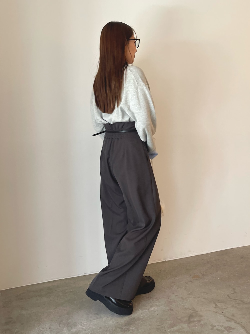 グレー系のニット/セーター、グレー系のその他パンツ、ゴールド系のピアス(両耳用)を着用したレディースの夏コーディネートの6枚目の写真