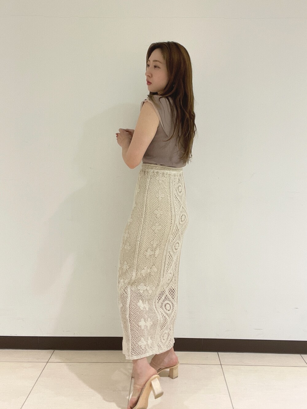 ホワイト系のスカート、ベージュ系のニット/セーターを着用したレディースの夏コーディネートの5枚目の写真