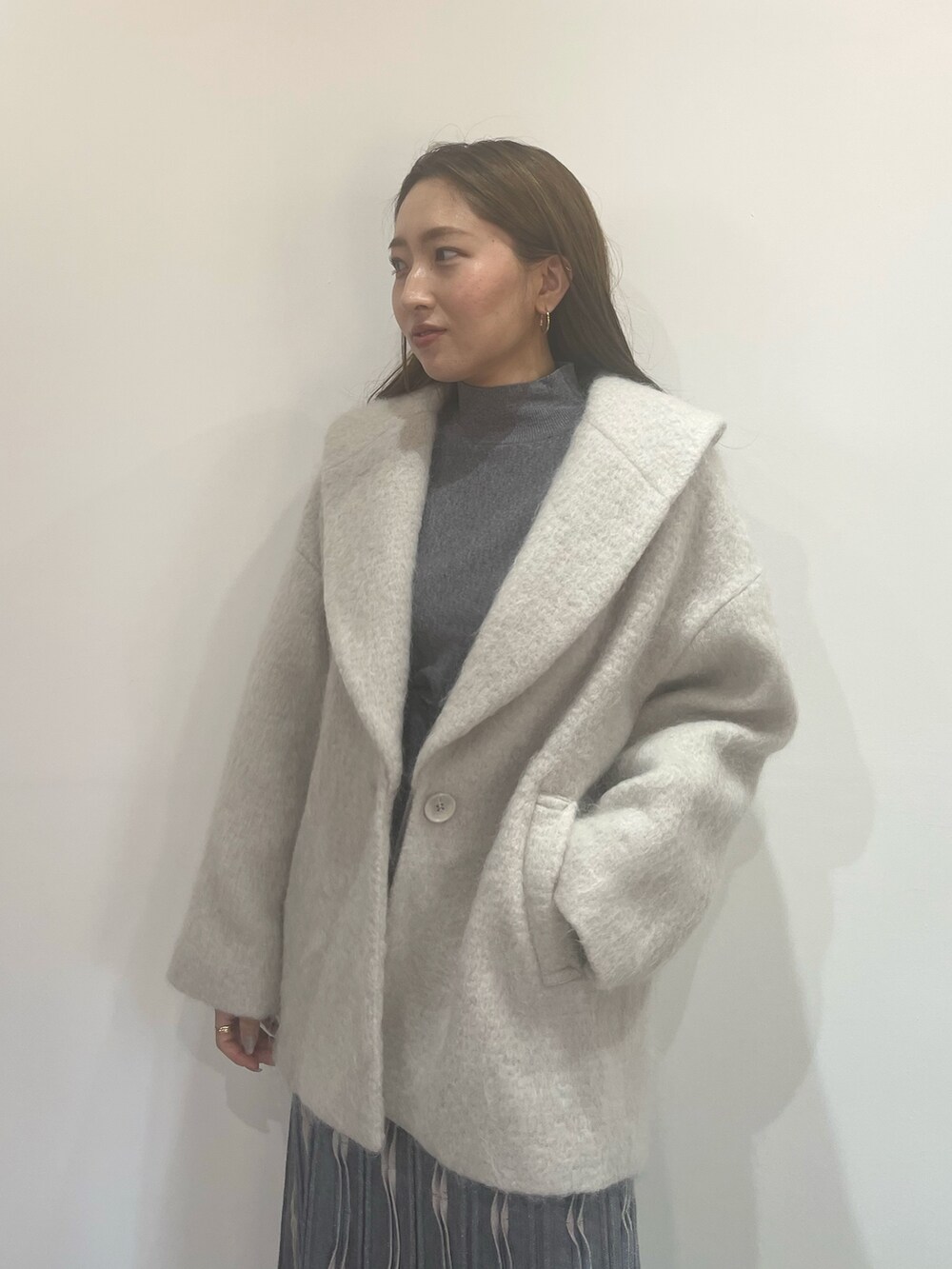 ホワイト系のブーツ、グレー系のワンピース、グレー系のその他アウターを着用したレディースの秋コーディネートの4枚目の写真