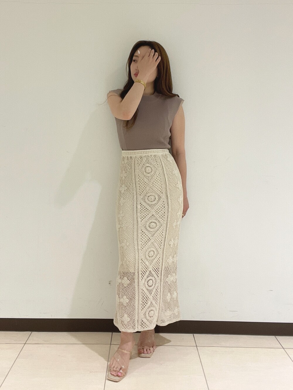 ホワイト系のスカート、ベージュ系のニット/セーターを着用したレディースの夏コーディネートの7枚目の写真