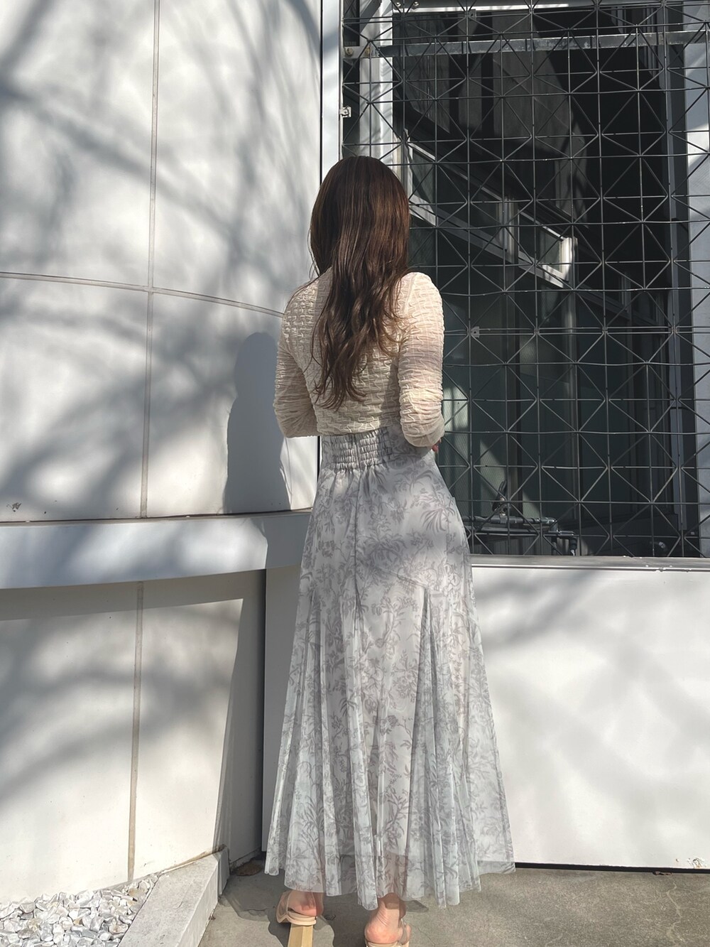 ホワイト系のTシャツ/カットソー、グリーン系のスカート、その他のサンダルを着用したレディースの冬コーディネートの5枚目の写真