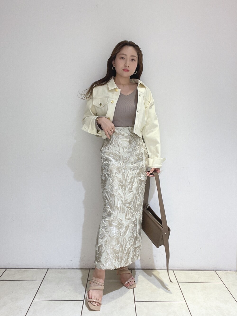 ベージュ系のスカート、ベージュ系のサンダル、ブラウン系のショルダーバッグを着用したレディースの春コーディネートの4枚目の写真