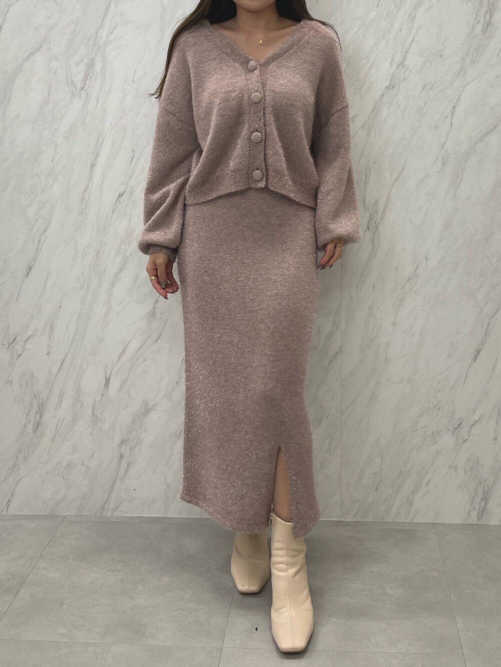 ピンク系のカーディガン/ボレロ、ピンク系のスカート、ホワイト系のブーツを着用したレディースの冬コーディネートの3枚目の写真