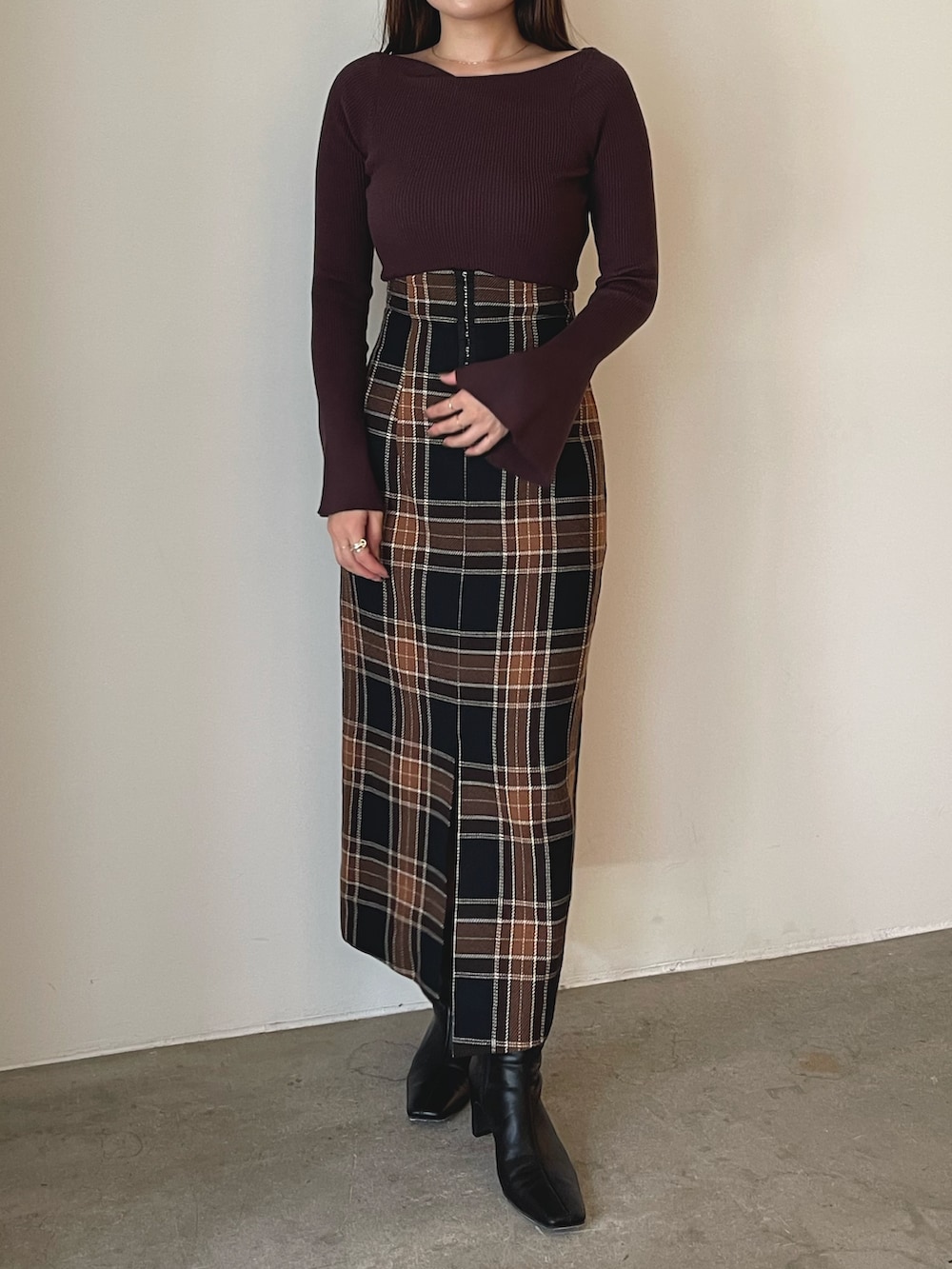ブラック系のブーツ、ブラウン系のスカート、ブラウン系のニット/セーターを着用したレディースの秋コーディネートの3枚目の写真
