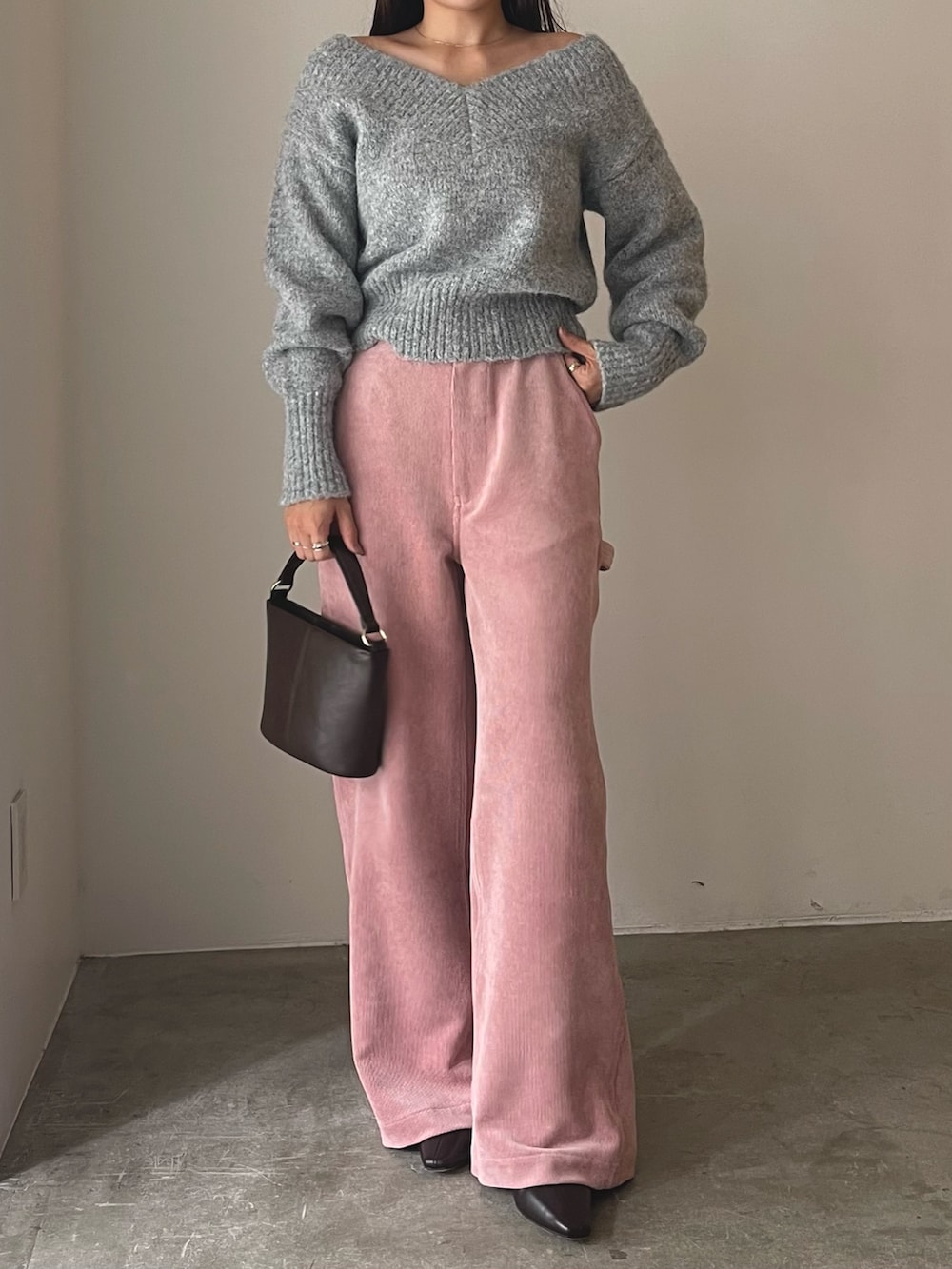 ブラウン系のハンドバッグ、ブラウン系のブーツ、ピンク系のその他パンツを着用したレディースの秋コーディネートの3枚目の写真