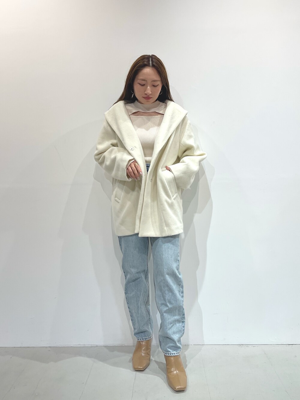 ホワイト系のニット/セーター、ベージュ系のブーツ、ホワイト系のその他アウターを着用したレディースの秋コーディネートの2枚目の写真