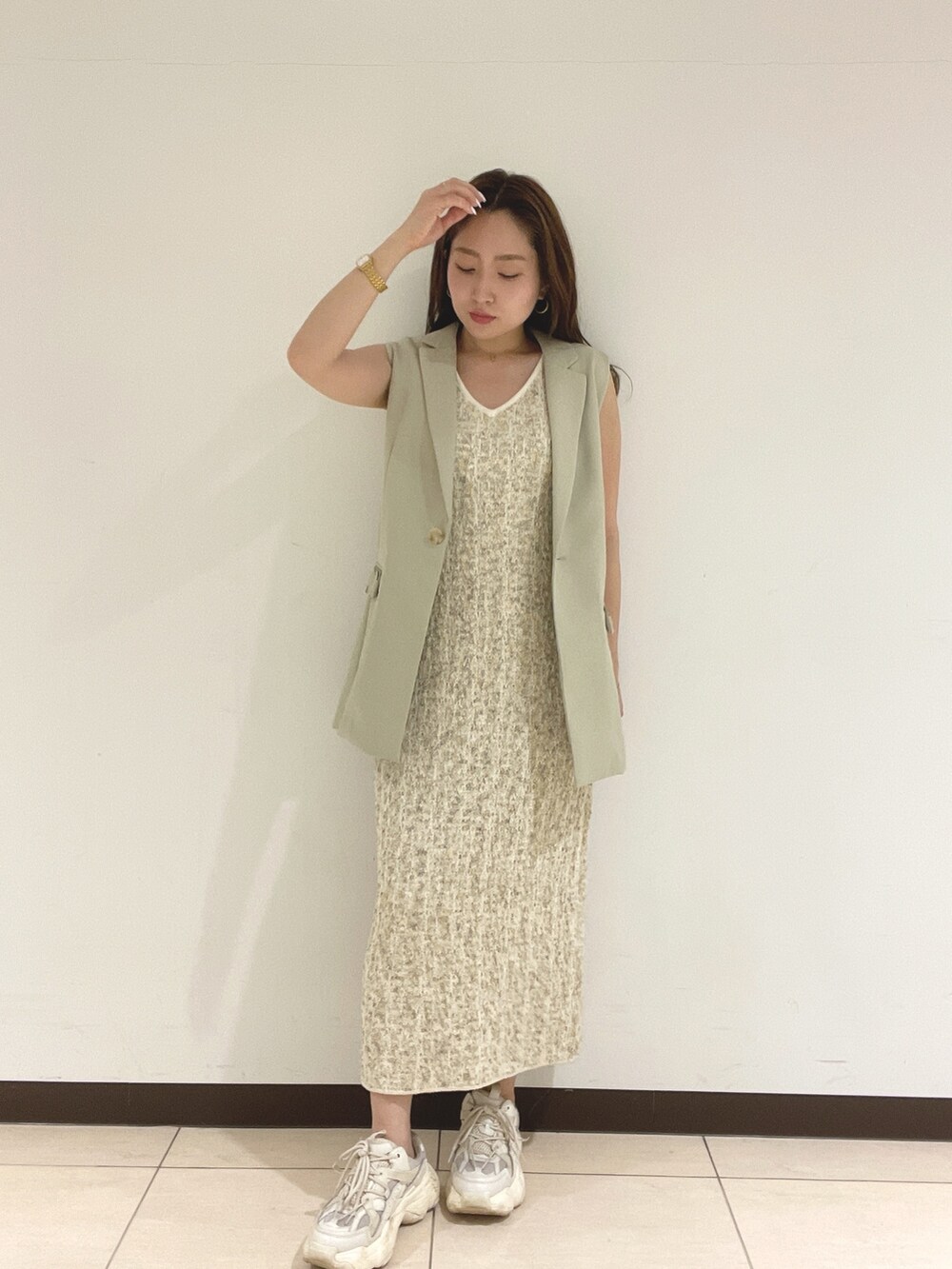 ホワイト系のワンピース、ベージュ系のベストを着用したレディースの春コーディネートの5枚目の写真