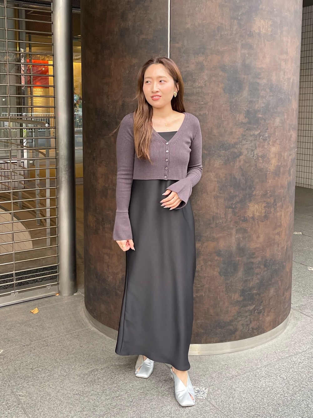 ブラック系のワンピース、シルバー系のパンプスを着用したレディースの冬コーディネートの6枚目の写真