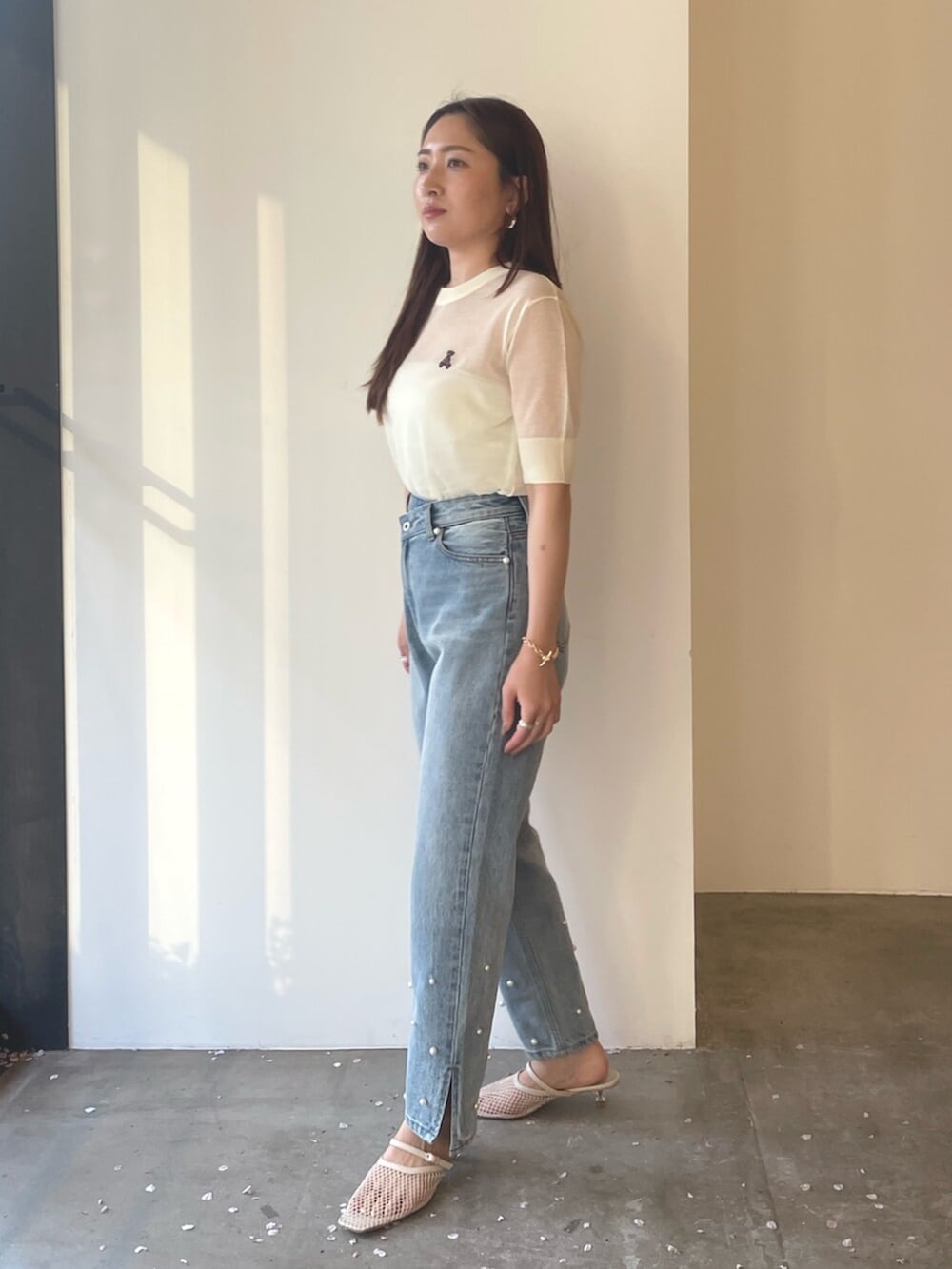 ホワイト系のサンダル、ブルー系のデニムパンツ、ホワイト系のTシャツ/カットソーを着用したレディースの春コーディネートの6枚目の写真