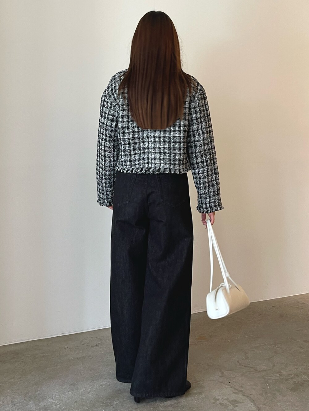 ホワイト系のショルダーバッグ、ブラック系のキャミソール、ブラック系のテーラードジャケットを着用したレディースの秋コーディネートの7枚目の写真