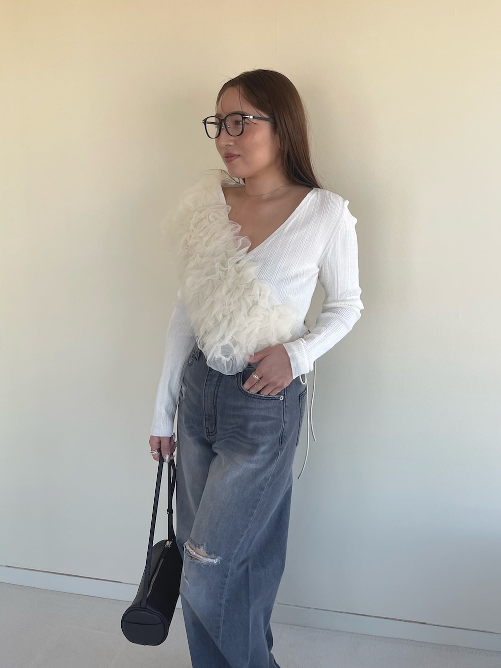 オレンジ系のサンダル、グレー系のデニムパンツ、ホワイト系のカーディガン/ボレロを着用したレディースの春コーディネートの5枚目の写真