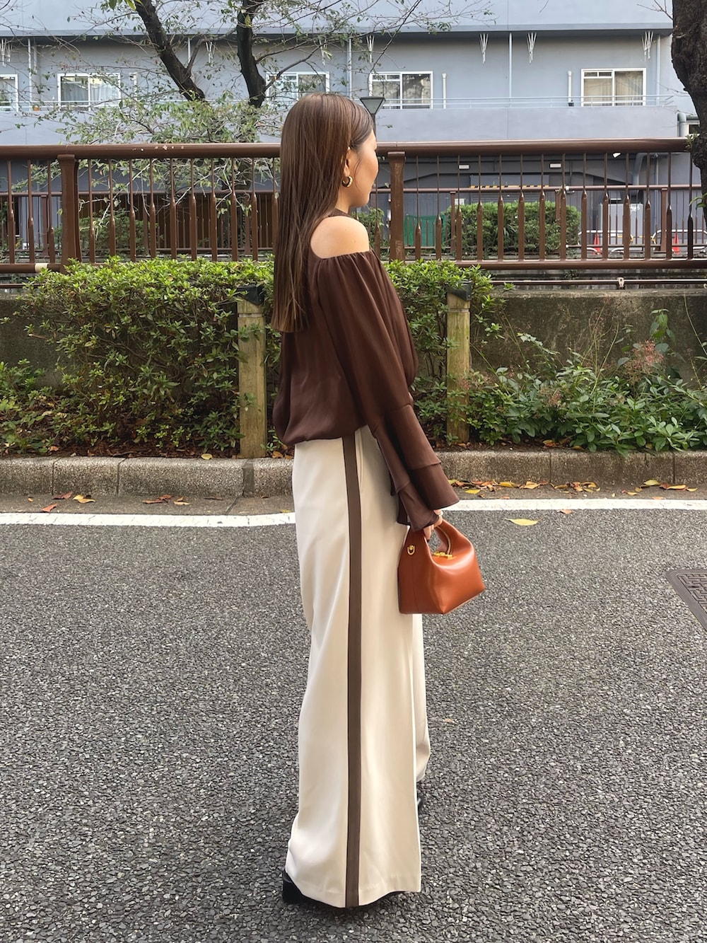 ブラック系のサンダル、ブラウン系のハンドバッグ、ホワイト系のその他パンツを着用したレディースの冬コーディネートの4枚目の写真