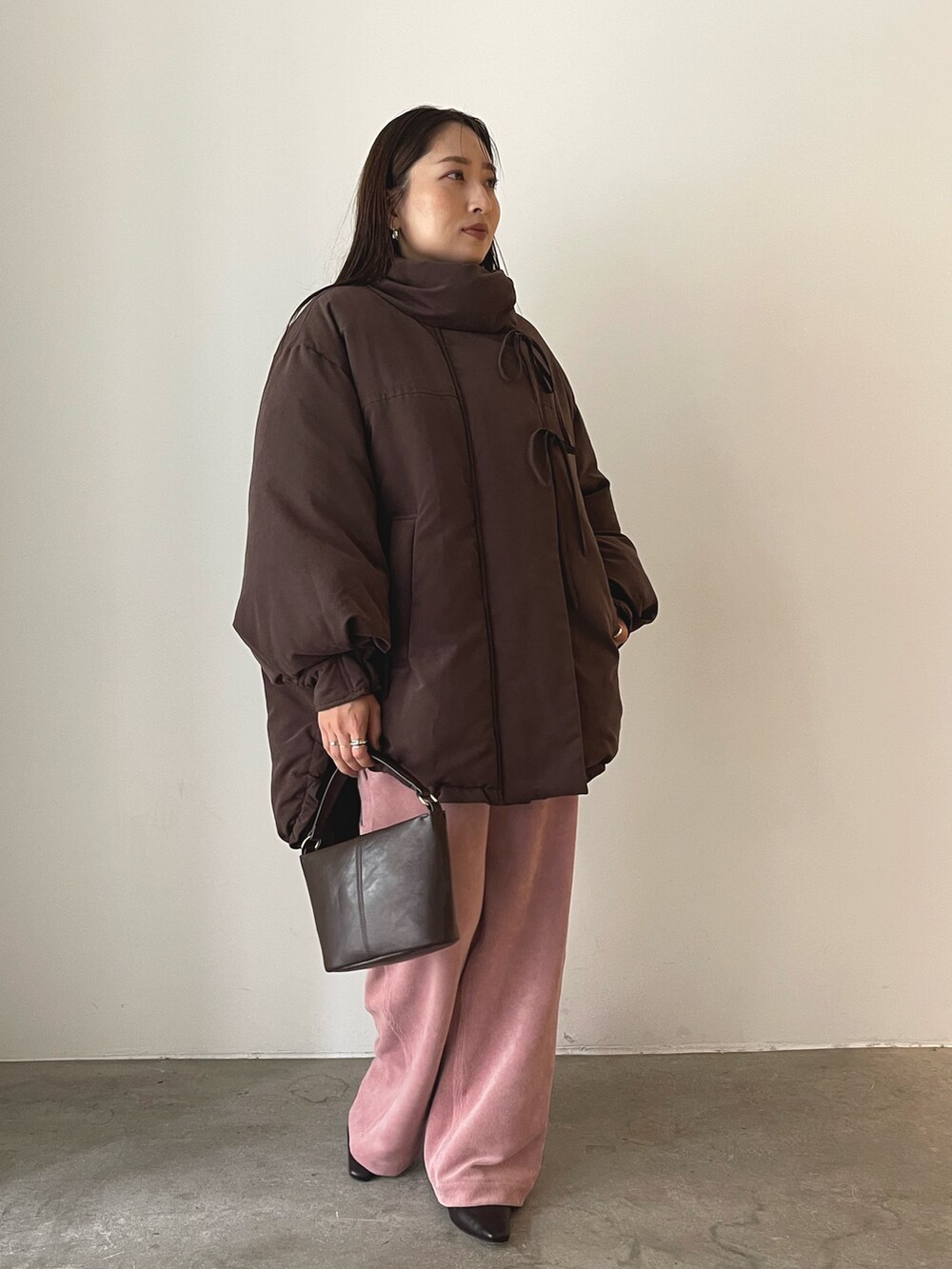 ブラウン系のハンドバッグ、ピンク系のその他パンツ、ブラウン系のブーツを着用したレディースの秋コーディネートの6枚目の写真