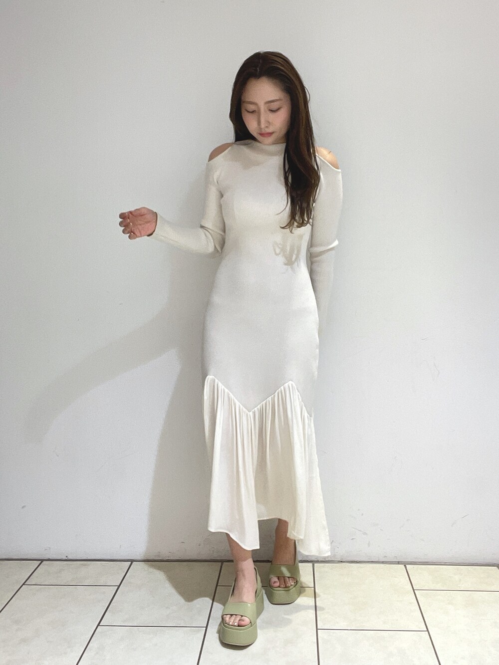 ホワイト系のワンピース、ベージュ系のサンダルを着用したレディースの冬コーディネートの5枚目の写真