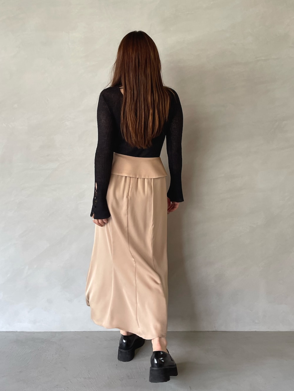 ベージュ系のスカート、ブラック系のニット/セーターを着用したレディースの夏コーディネートの5枚目の写真