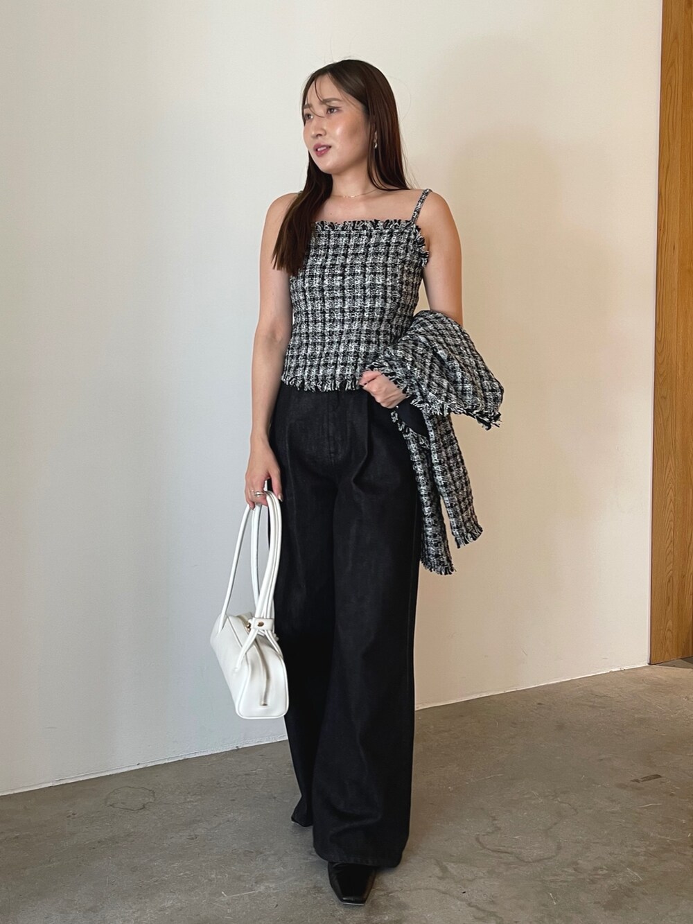 ブラック系のブーツ、ブラック系のテーラードジャケット、ブラック系のデニムパンツを着用したレディースの夏コーディネートの2枚目の写真