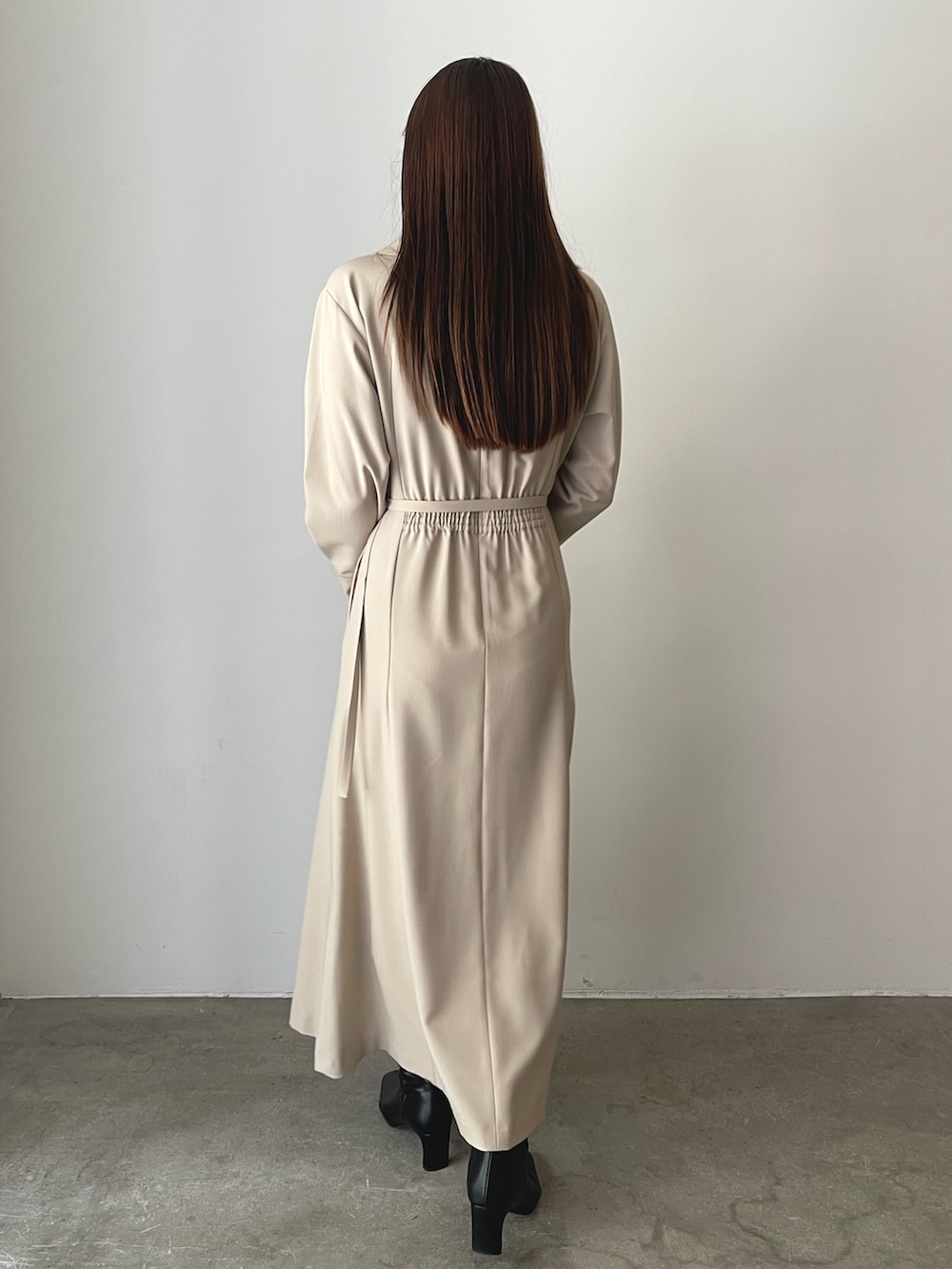 ブラック系のブーツ、ベージュ系のワンピース、イエロー系のハンドバッグを着用したレディースの秋コーディネートの6枚目の写真