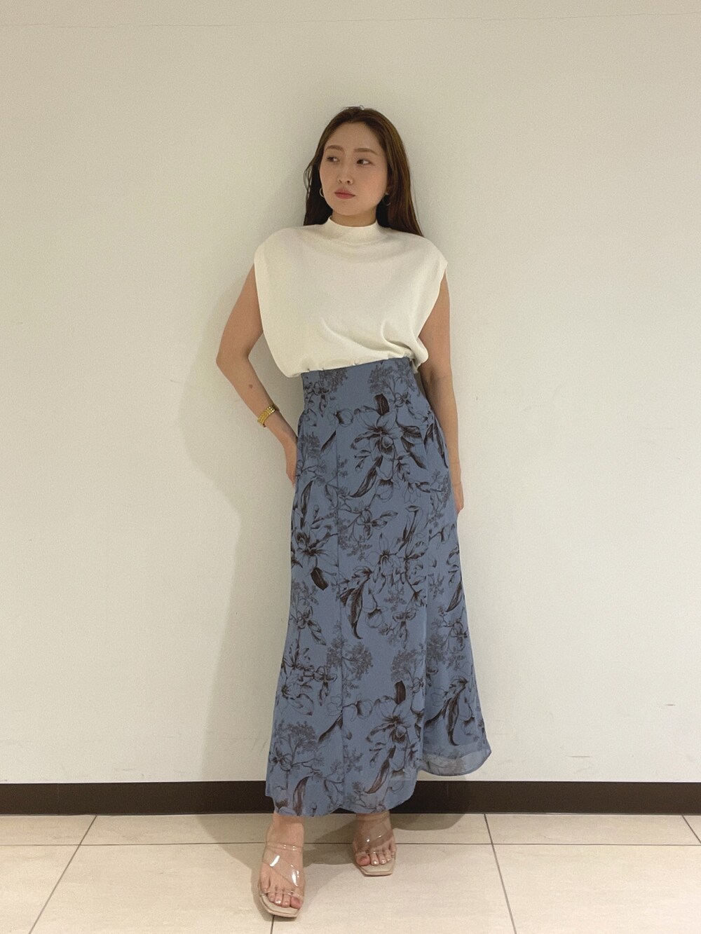 ブルー系のスカート、ホワイト系のニット/セーターを着用したレディースの夏コーディネートの4枚目の写真