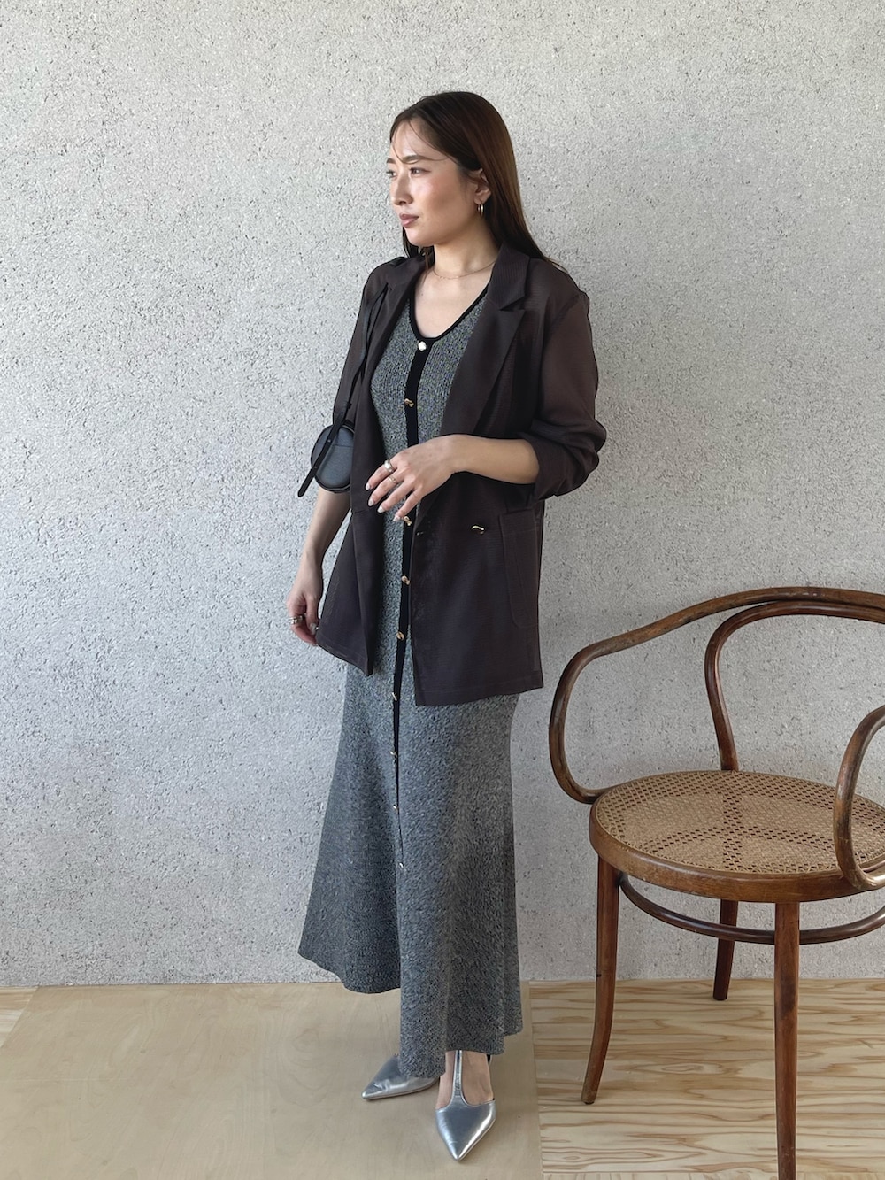 シルバー系のパンプス、ブラック系のワンピース、ブラウン系のテーラードジャケットを着用したレディースの春コーディネートの3枚目の写真