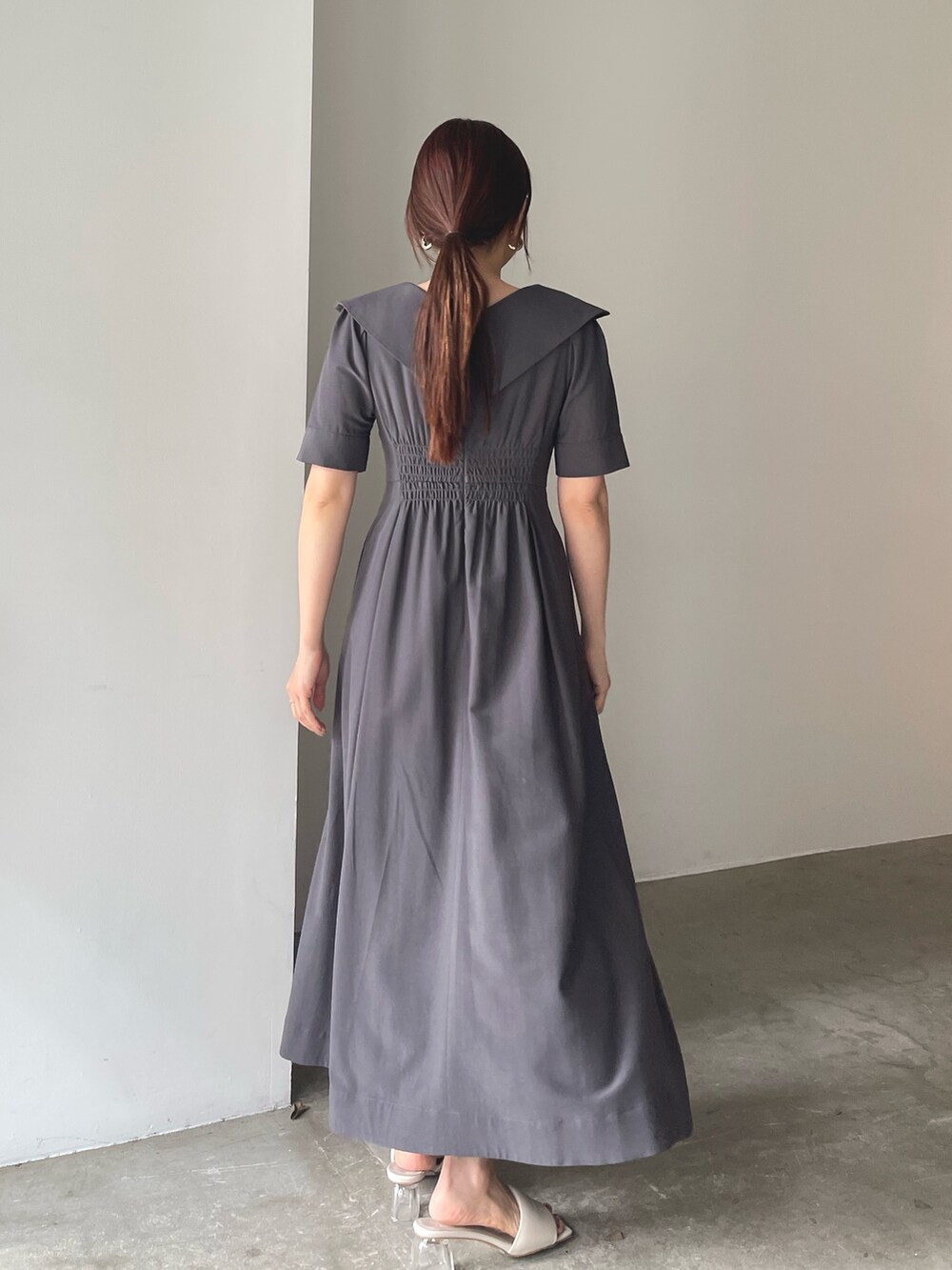 ホワイト系のサンダル、グレー系のワンピース、ゴールド系のピアス（両耳用）を着用したレディースの春コーディネートの5枚目の写真