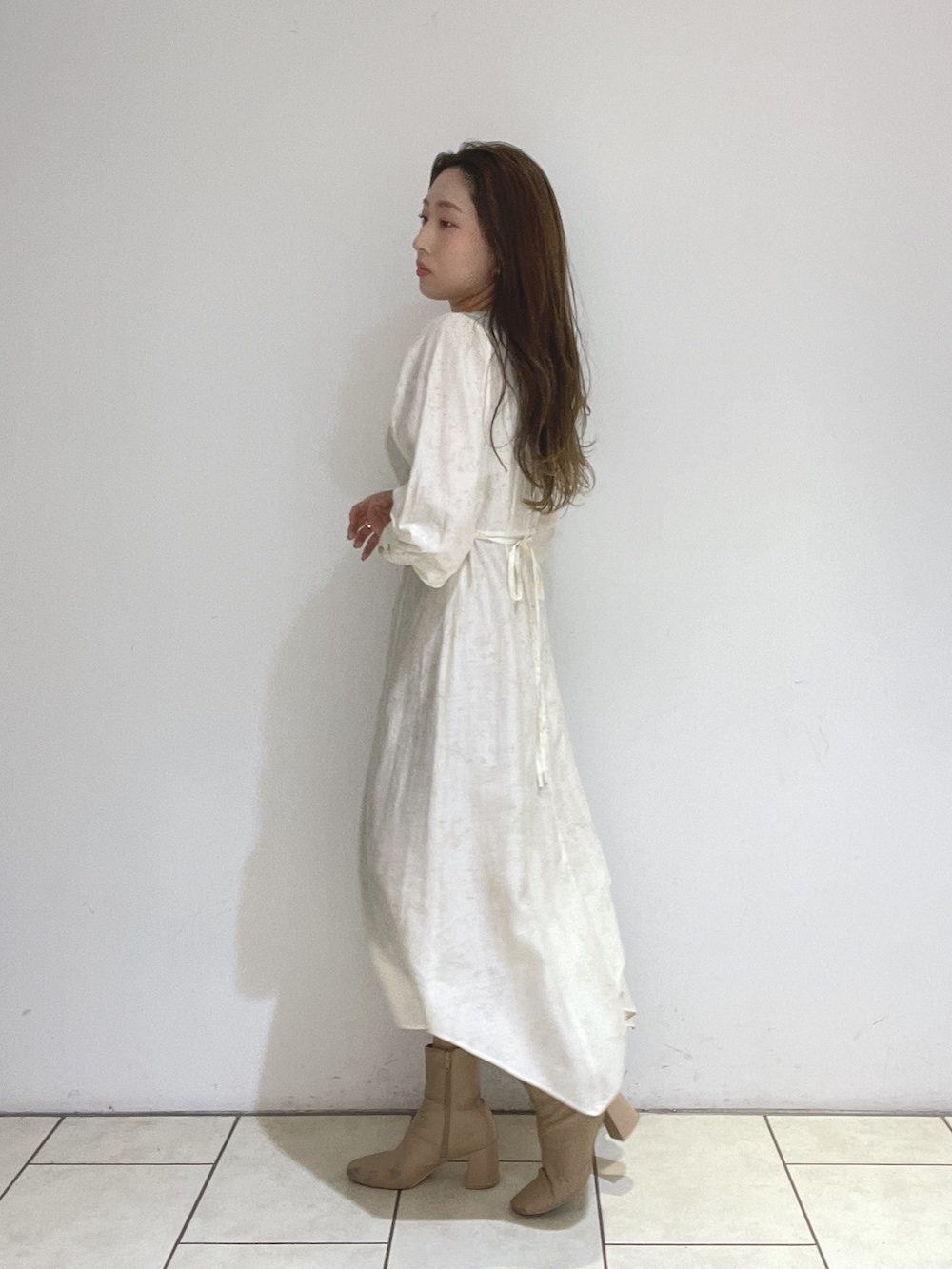 ベージュ系のブーツ、ホワイト系のワンピースを着用したレディースの冬コーディネートの7枚目の写真