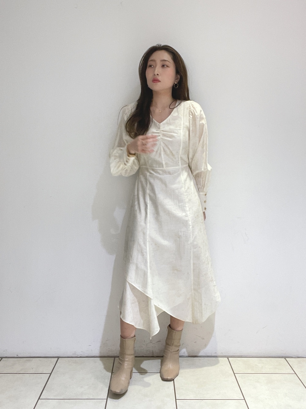 ベージュ系のブーツ、ホワイト系のワンピースを着用したレディースの冬コーディネートの5枚目の写真