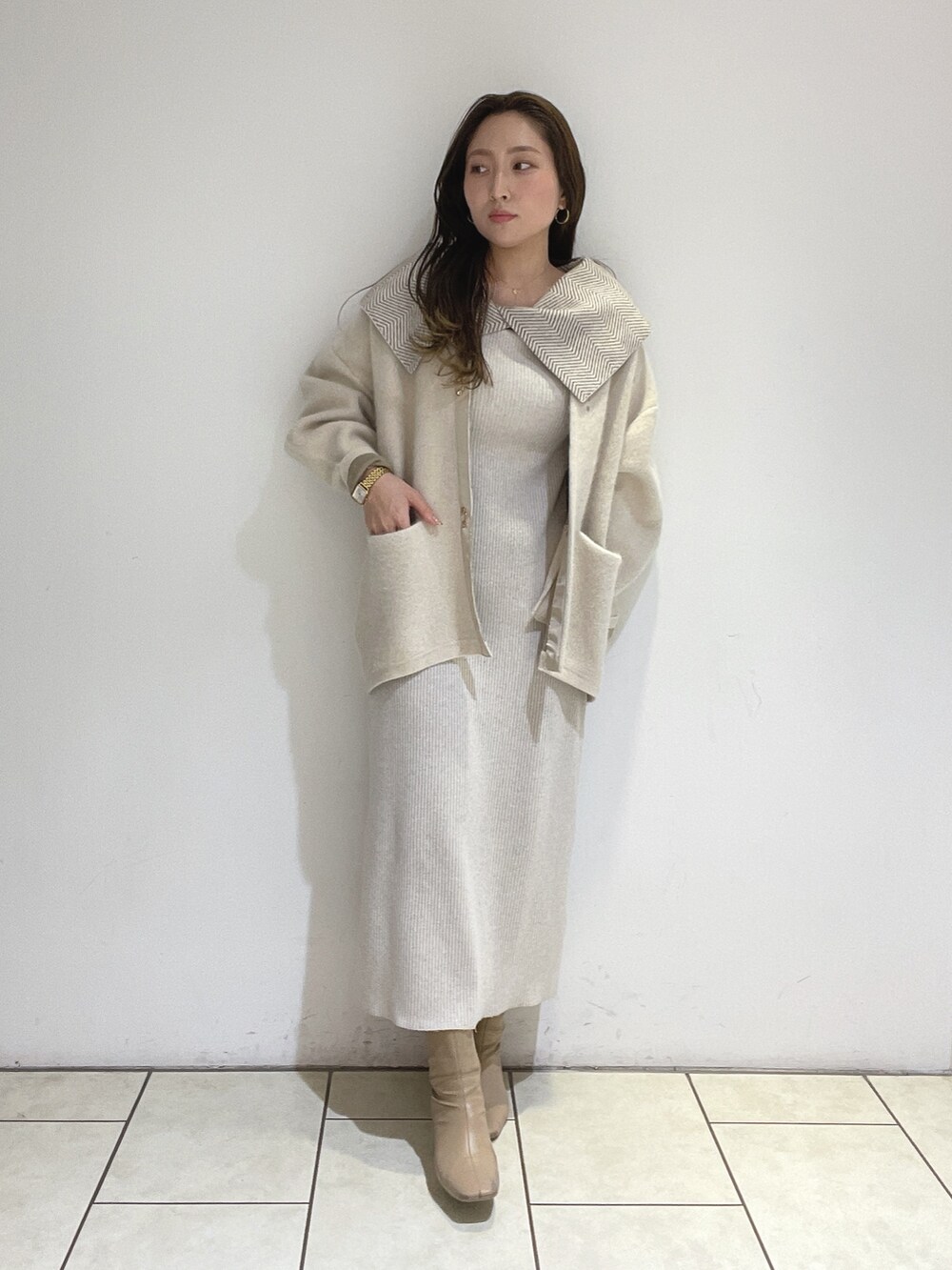 ホワイト系のワンピース、ホワイト系のカーディガン/ボレロ、ベージュ系のブーツを着用したレディースの冬コーディネートの5枚目の写真