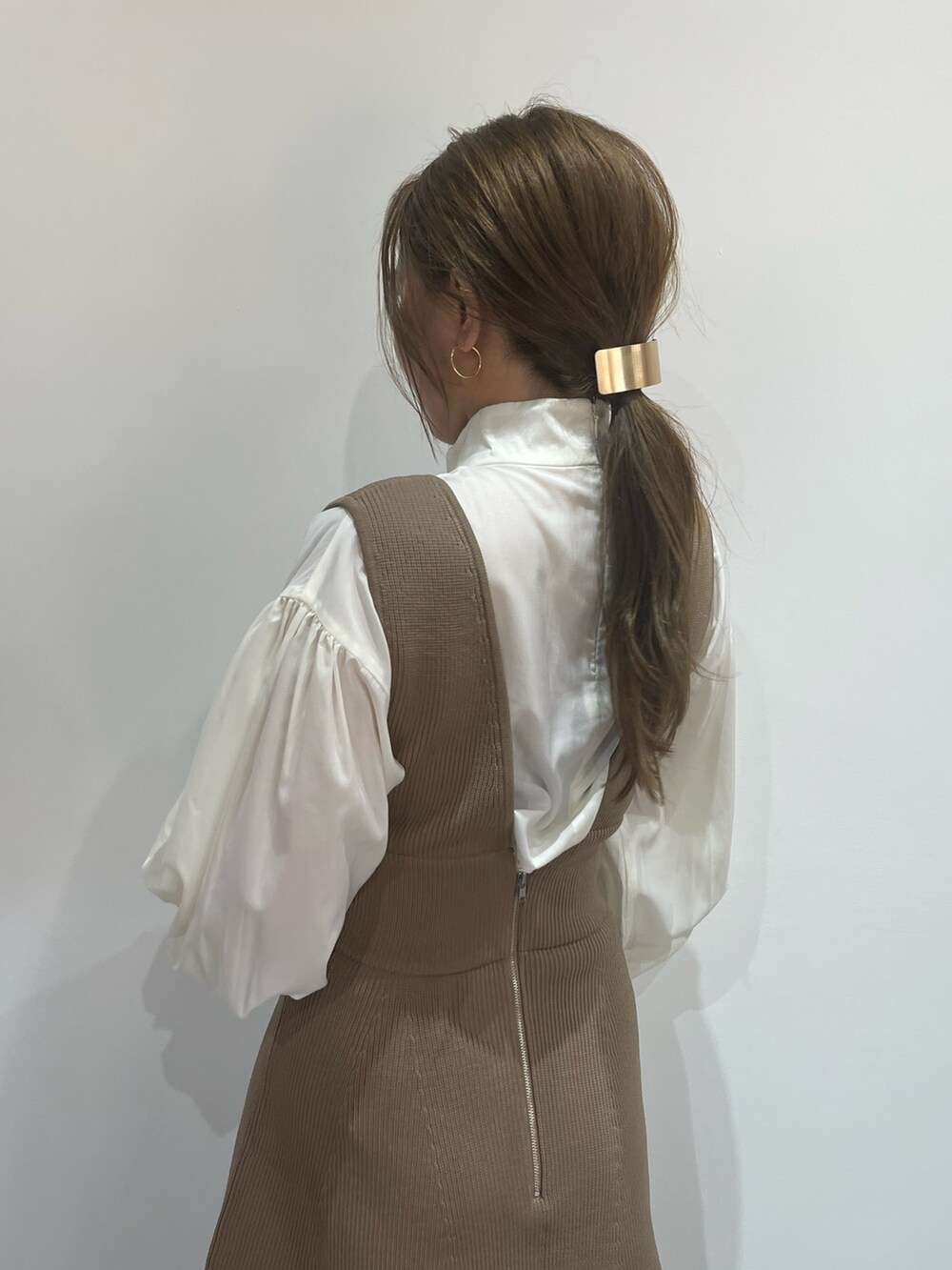 ブラック系のブーツ、ベージュ系のジャンパースカート、ホワイト系のシャツ/ブラウスを着用したレディースの秋コーディネートの6枚目の写真