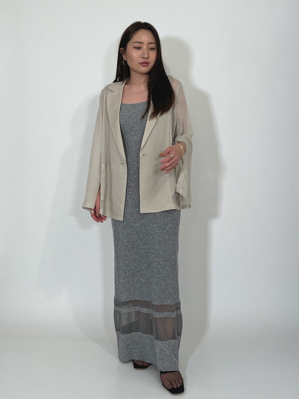 ホワイト系のテーラードジャケット、グレー系のワンピース、ブラック系のサンダルを着用したレディースの夏コーディネートの7枚目の写真