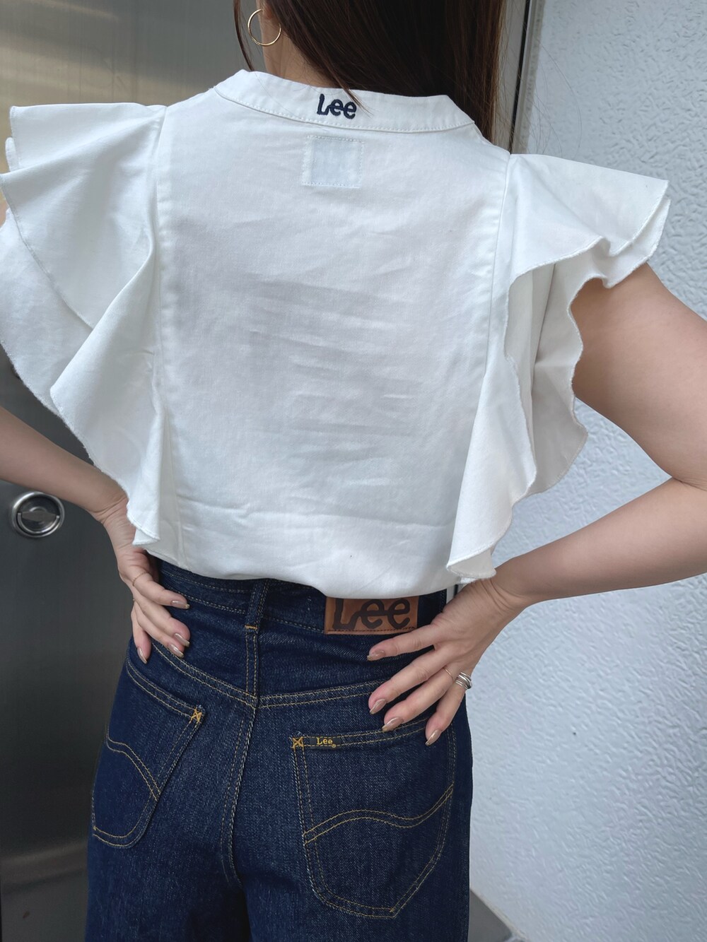 ホワイト系のサンダル、ホワイト系のシャツ/ブラウス、ブルー系のデニムパンツを着用したレディースの春コーディネートの10枚目の写真