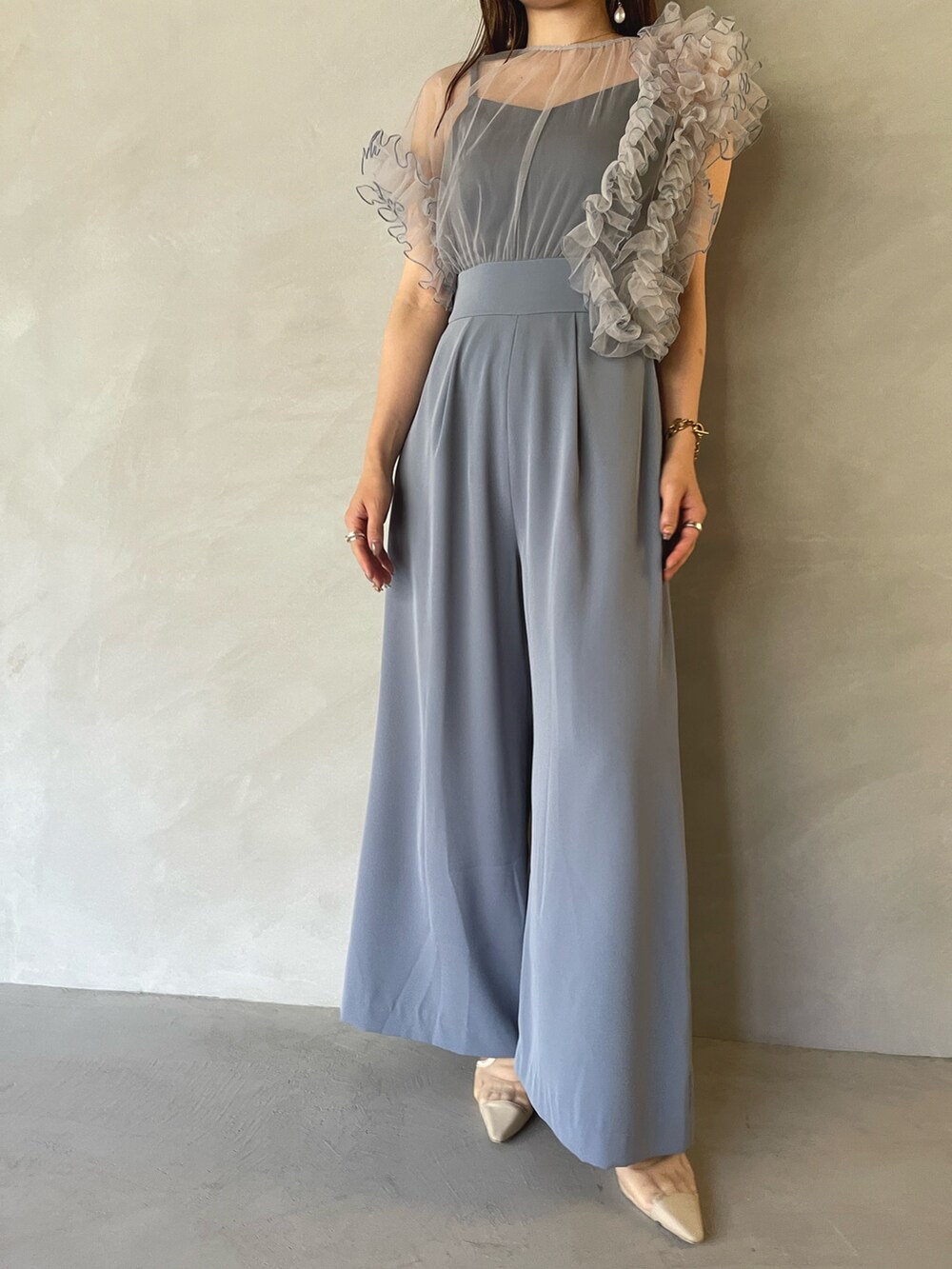 ブルー系のパンツドレス、ゴールド系のピアス（両耳用）を着用したレディースの夏コーディネートの10枚目の写真