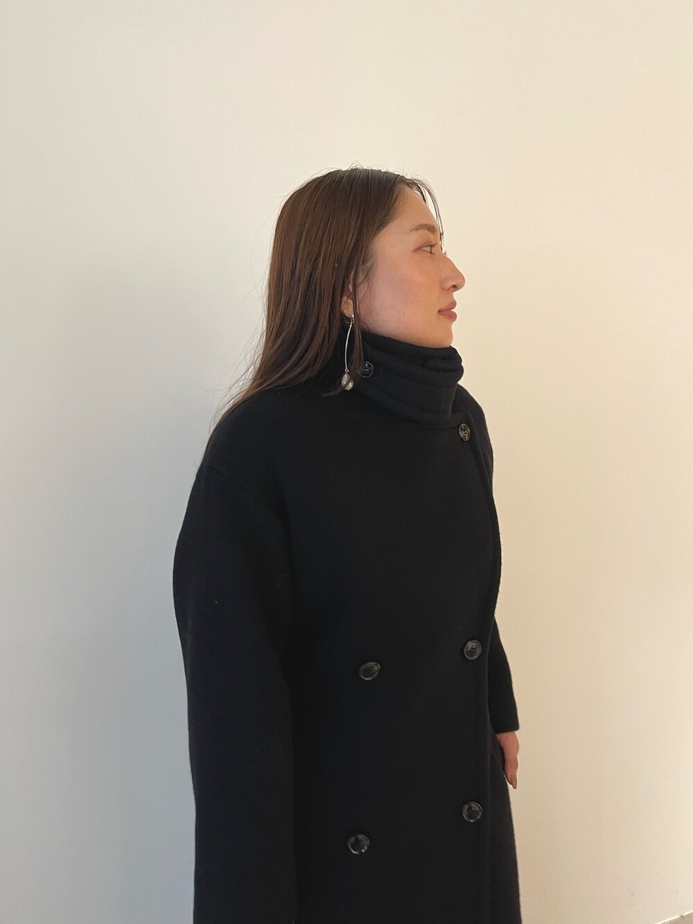 シルバー系のパンプス、ブラック系のハンドバッグ、ブラック系のドレスを着用したレディースの秋コーディネートの8枚目の写真