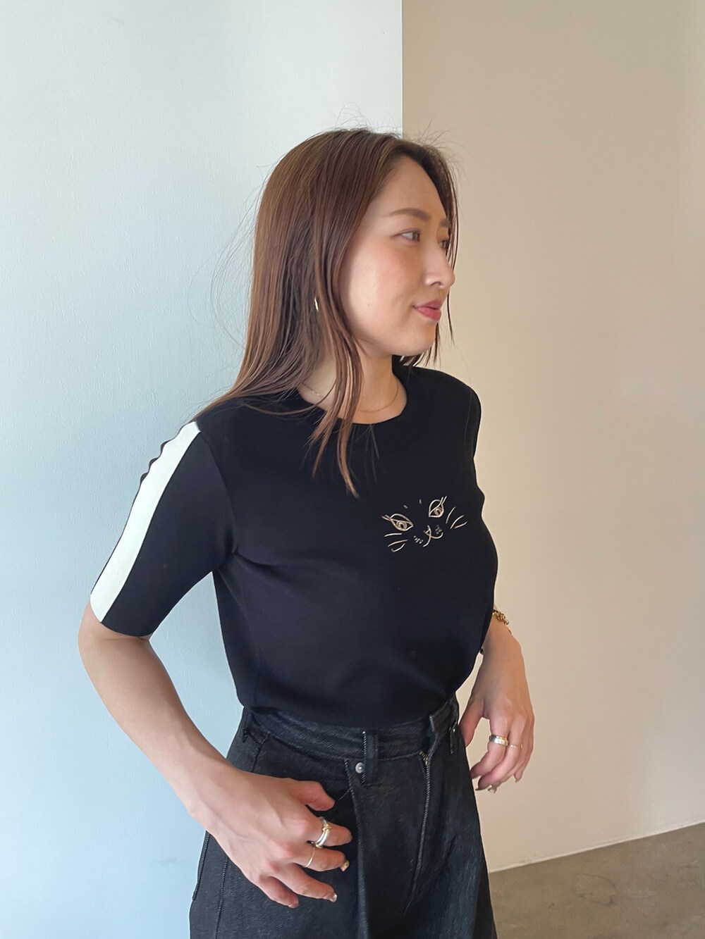 ブラック系のサンダル、ブラック系のニット/セーター、ブラック系のデニムパンツを着用したレディースの夏コーディネートの7枚目の写真